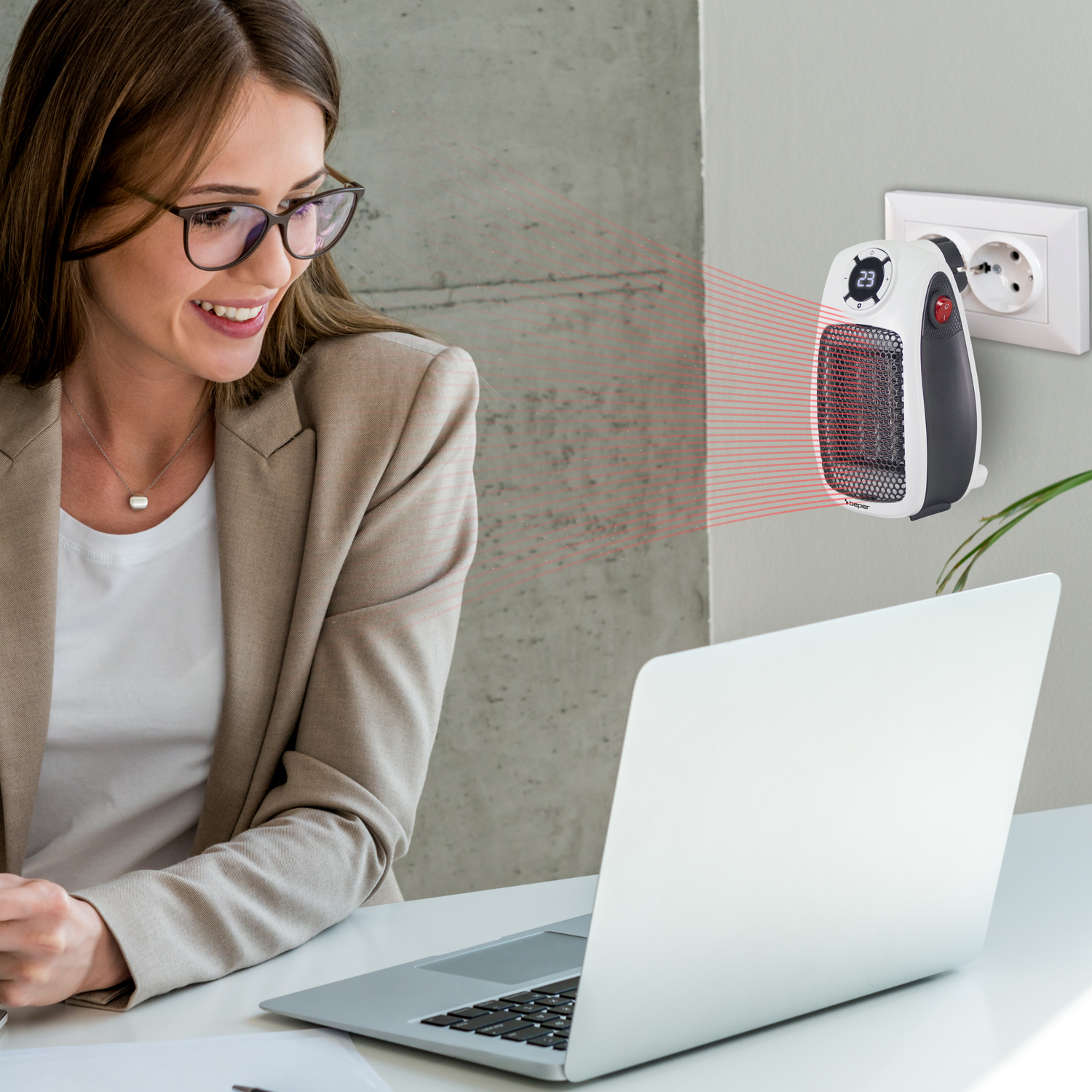 Donna con occhiali sorride al laptop. Un termoventilatore è collegato al muro. Linee rosse di calore sono visibili.