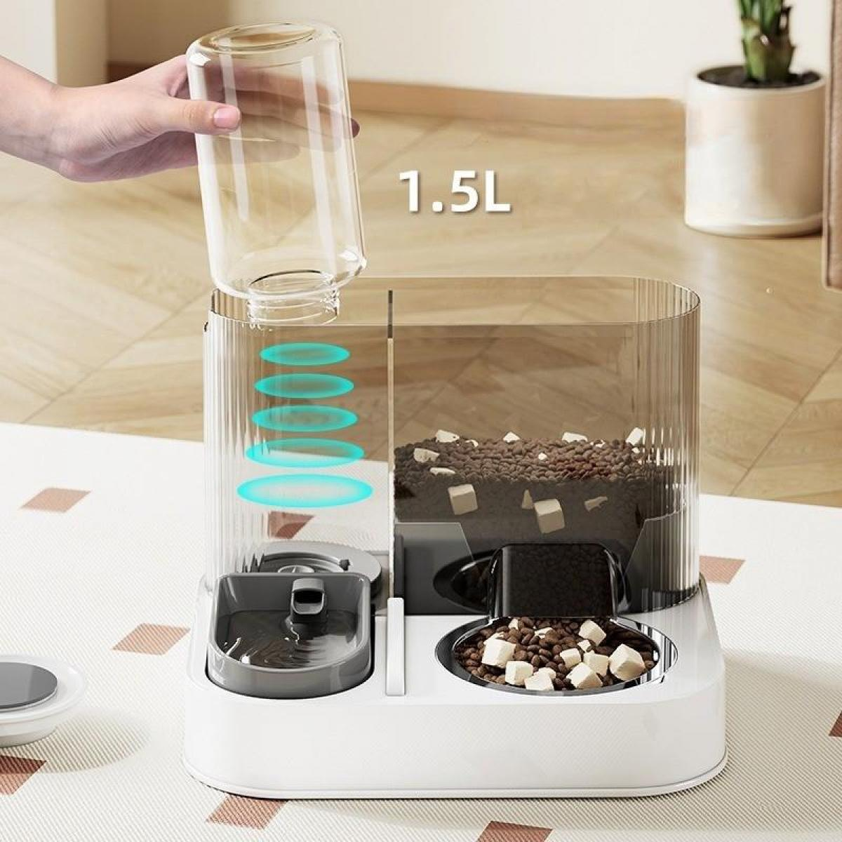 Eine Hand gießt Wasser in einen transparenten Haustierfutterautomaten. Der Futterautomat hat Fächer für Futter und Wasser, mit Kibbeln und Würfelfutter.