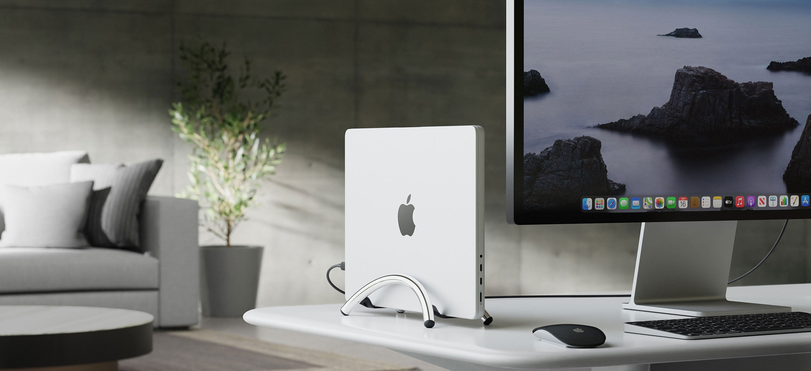 Ein weißer Apple-Computer auf einem Schreibtisch mit einem Monitor, der eine Meereslandschaft zeigt. Maus und Tastatur sind ebenfalls auf dem Schreibtisch.
