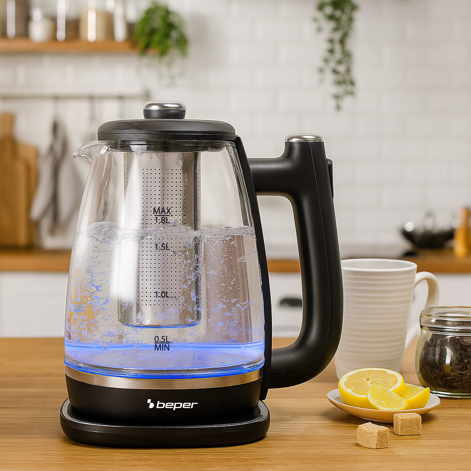 Un bollitore elettrico in vetro con acqua bollente, fette di limone, zollette di zucchero e una tazza da tè su una superficie di legno. Sfondo cucina.
