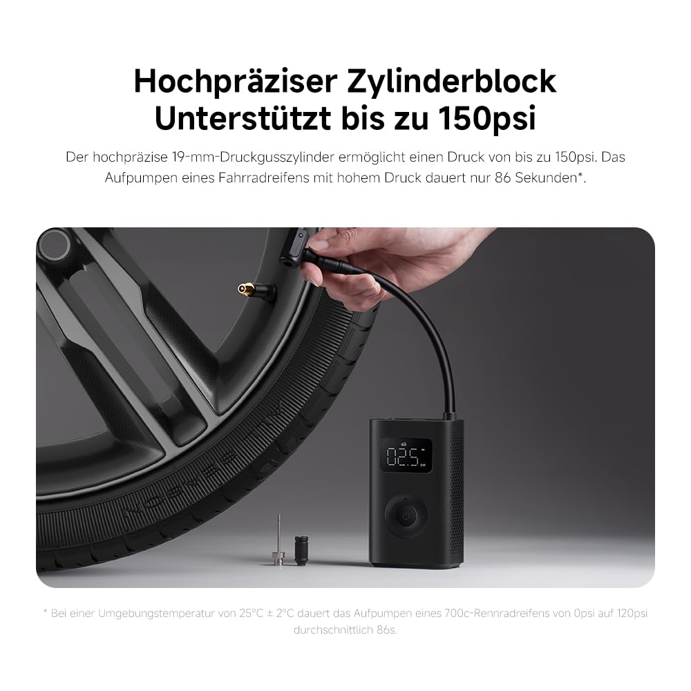Eine Person pumpt einen Fahrradreifen mit einer schwarzen Luftpumpe auf. Die Pumpe zeigt '02.5'. Reifen und Pumpe sind schwarz.