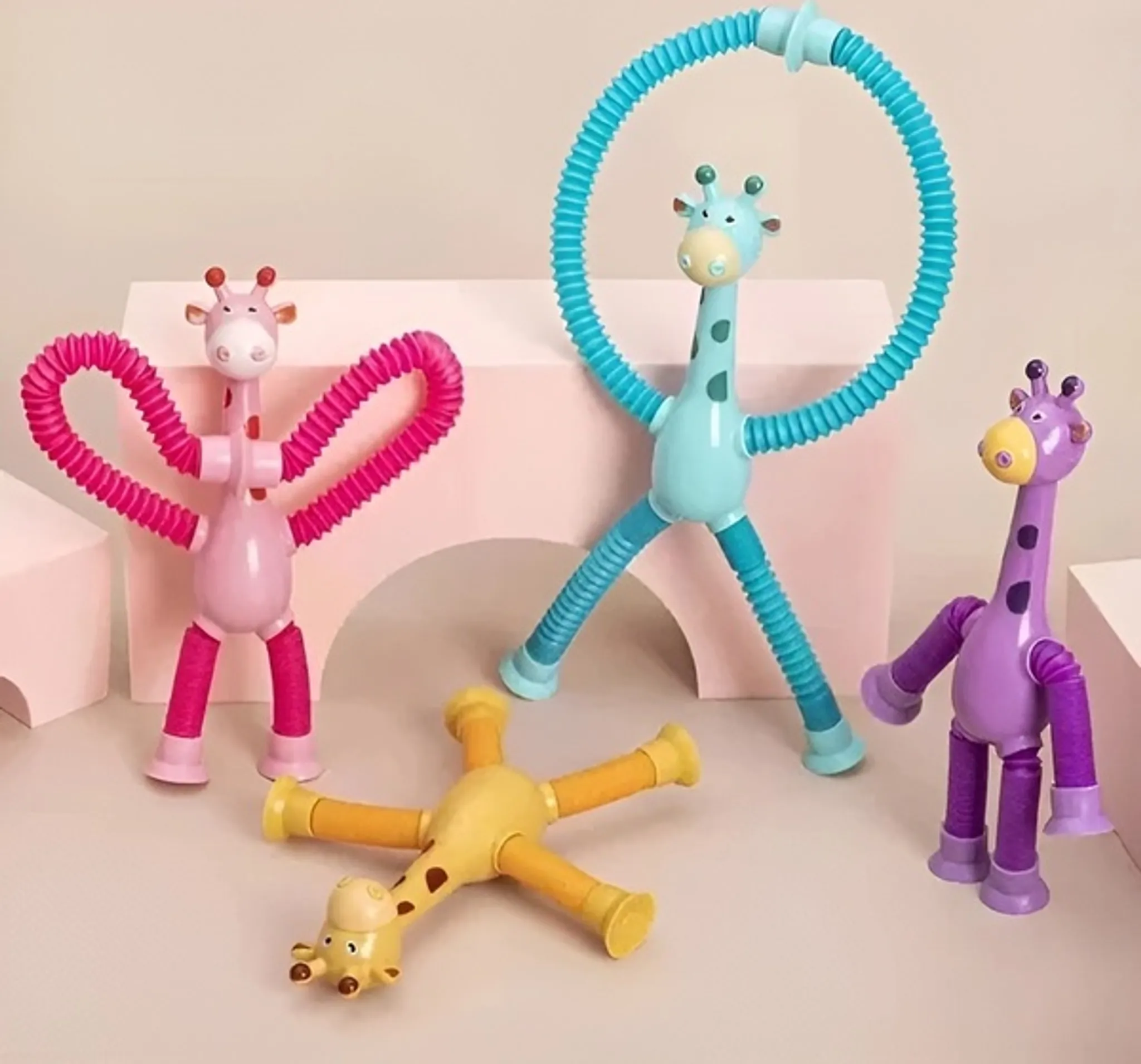 Bunte Spielzeuggiraffen mit flexiblen Hälsen und Gliedmaßen in verschiedenen Posen. Pinke, blaue, gelbe und lila Giraffen auf hellem Hintergrund.