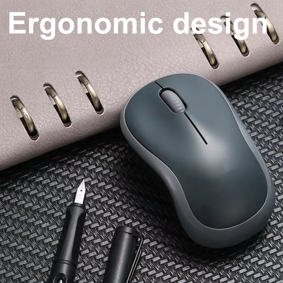 Eine graue Computermaus liegt auf einer gemusterten Oberfläche. Ein Stift und ein Notizbuch sind ebenfalls vorhanden. Der Ausdruck 'Ergonomisches Design' steht oben.