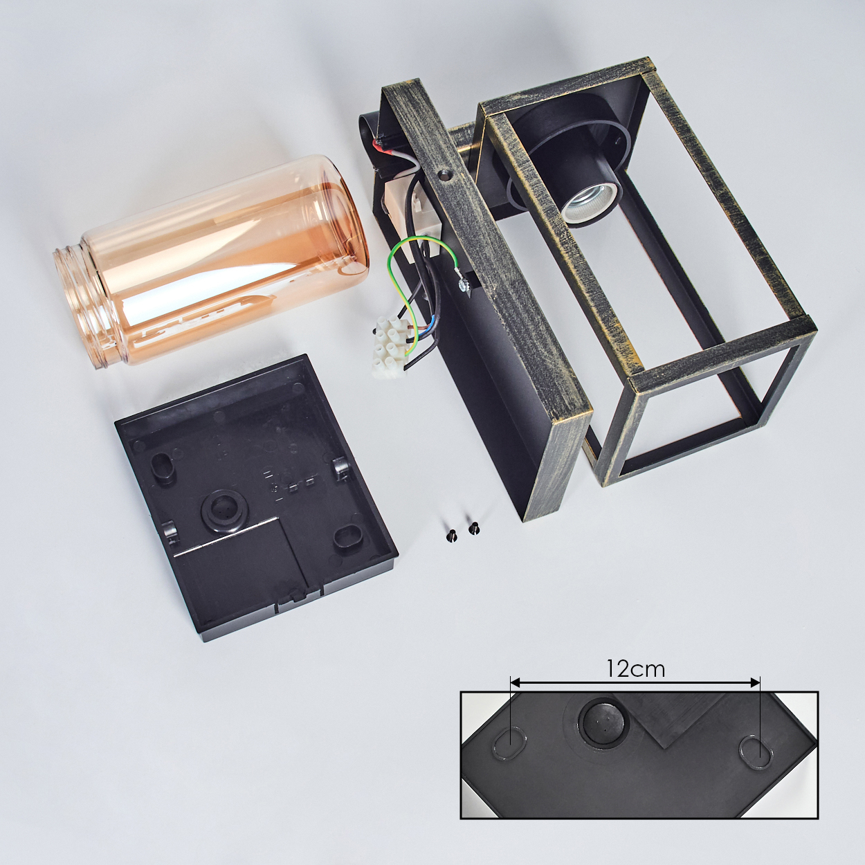 Zerlegte Lampenteile: quadratischer Rahmen, Glaszylinder, schwarze Basis, Drähte, Schrauben und ein 12cm Maßdetail.