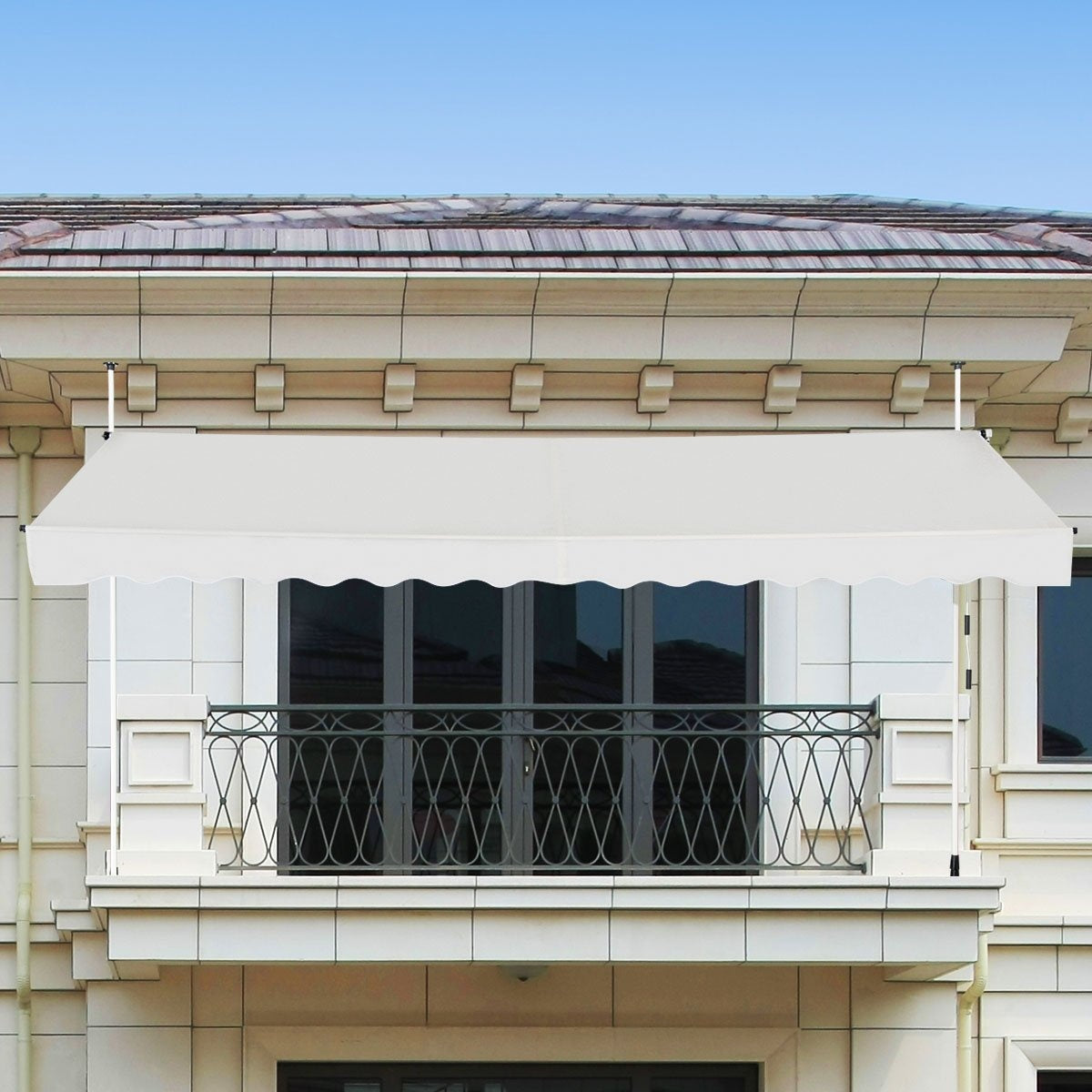 Een witte luifel bedekt een balkon met een smeedijzeren balustrade. Het gebouw heeft een pannendak en een blauwe lucht op de achtergrond.