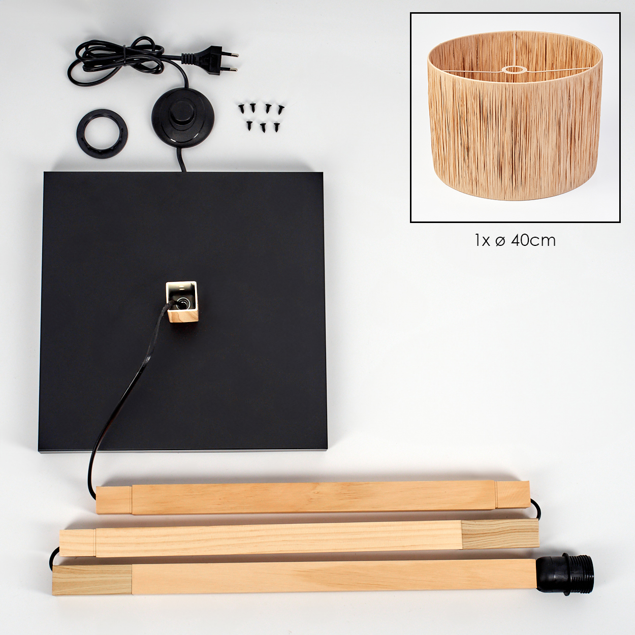 Eine zerlegte Lampe mit schwarzem Sockel, Holzstützen, beigem Lampenschirm, Netzkabel und Schrauben sind ausgebreitet.