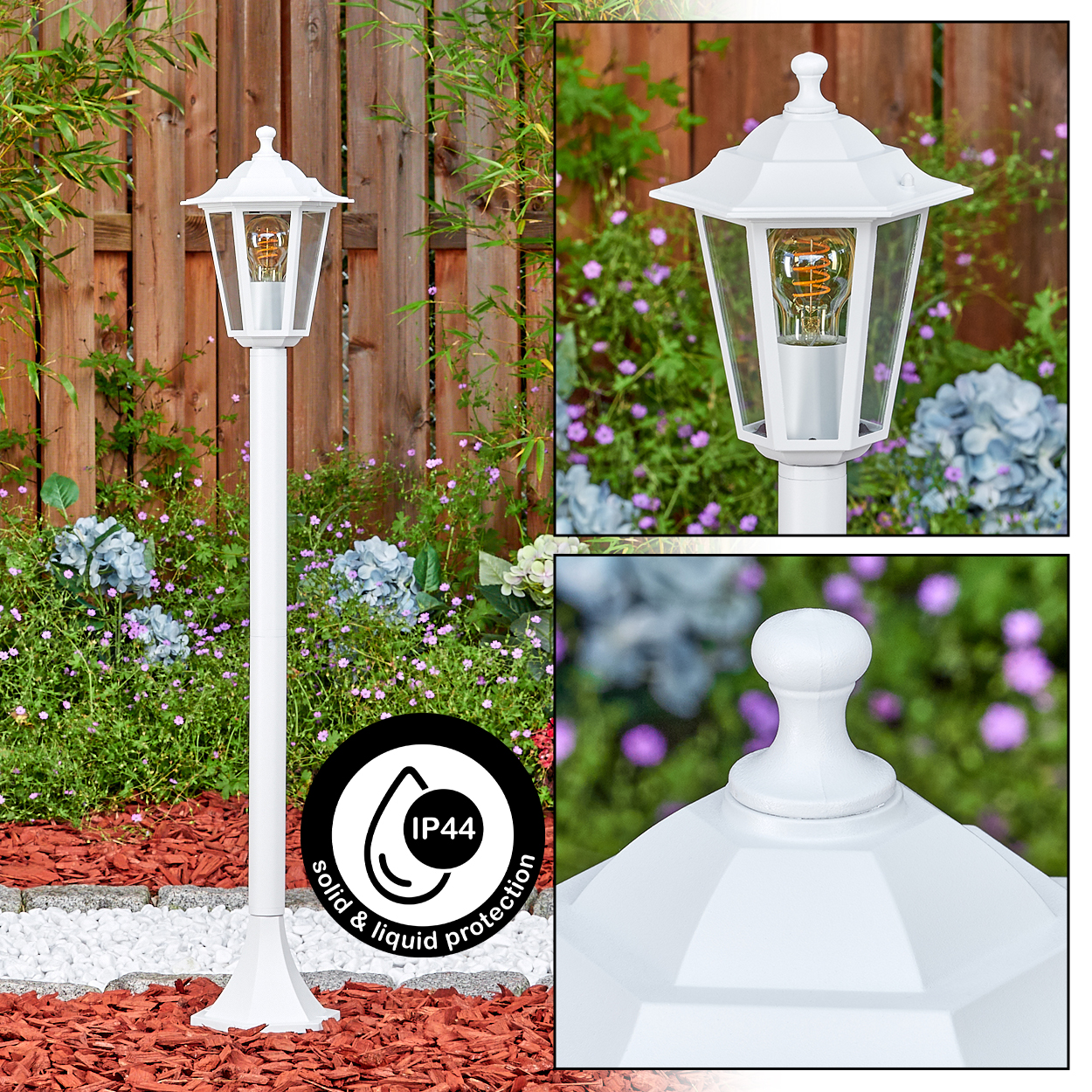 Eine weiße Außenlampe mit Glasgehäuse. Sie befindet sich in einem Garten mit Blumen und einem Holzzaun. IP44 Schutz.
