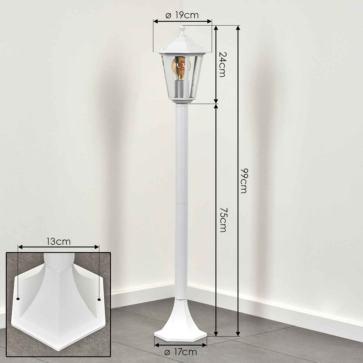 Eine weiße Außenlampe mit angegebenen Abmessungen. Die Lampe hat ein Glasgehäuse, eine Glühbirne und einen quadratischen Sockel.