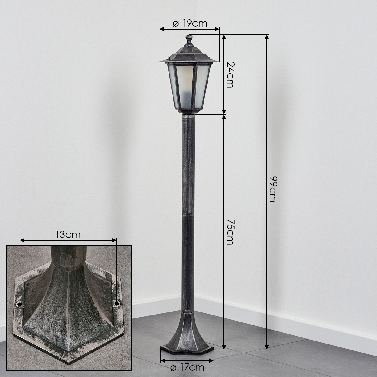 Eine schwarz-silberne Außenlampe mit Maßen. Die Lampe hat einen rechteckigen Sockel und eine sechseckige Oberseite.