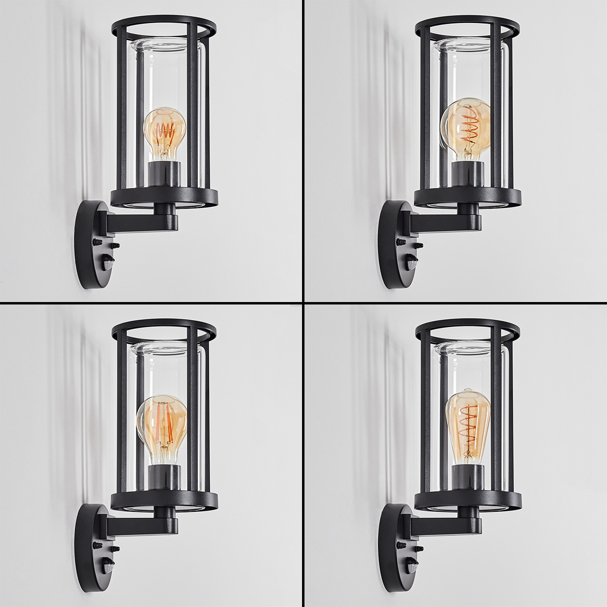 Vier schwarze Wandleuchten mit klarem Glas und Edison-Glühbirnen an einer weißen Wand.