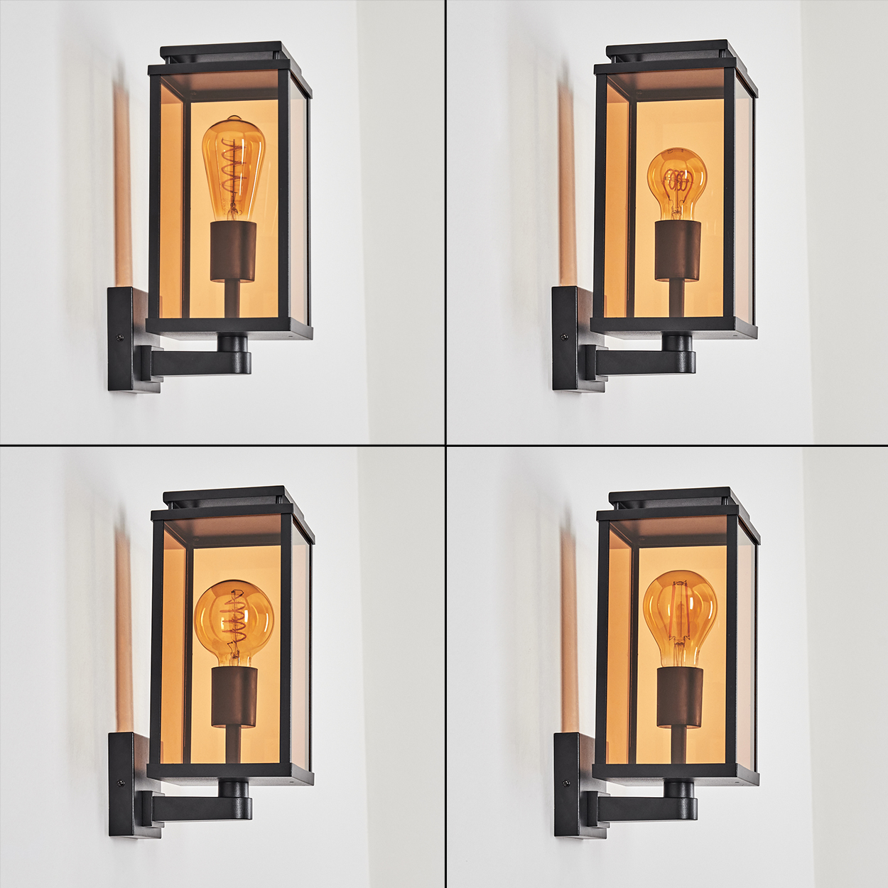 Vier Wandlampen mit bernsteinfarbenem Glas und schwarzen Metallrahmen. Jede Lampe hat eine Glühbirne mit warmem Schein, montiert an einer weißen Wand.