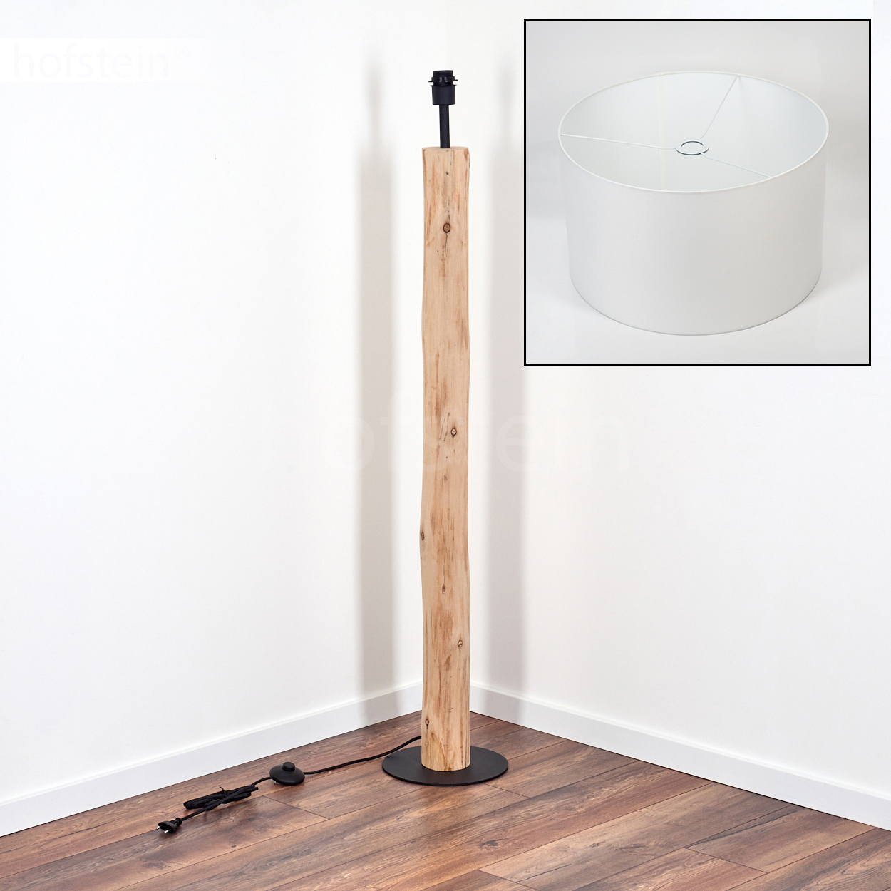 Eine Stehlampe aus Holz mit schwarzem Sockel und Oberteil. Ein weißer Lampenschirm befindet sich oben rechts. Der Boden ist aus Holz.