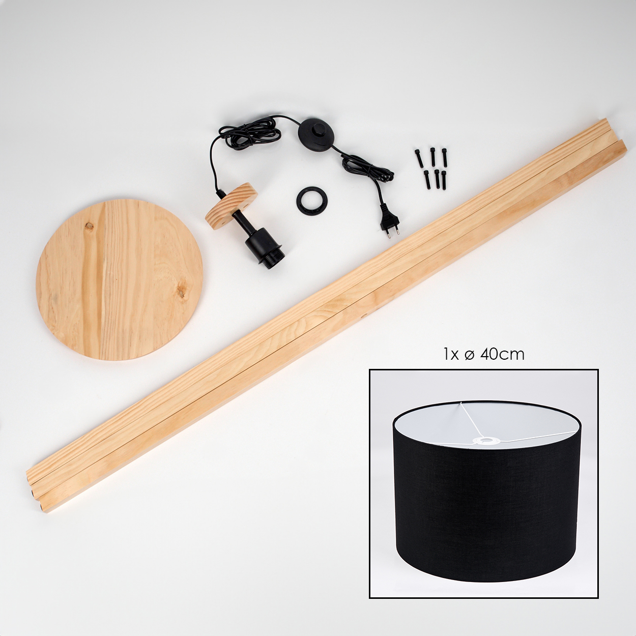 Lampenbausatz: Holzsockel, lange Bretter, schwarze Lampenfassung, Schrauben und Lampenschirm. Schwarzer Lampenschirm mit weißem Innenraum.