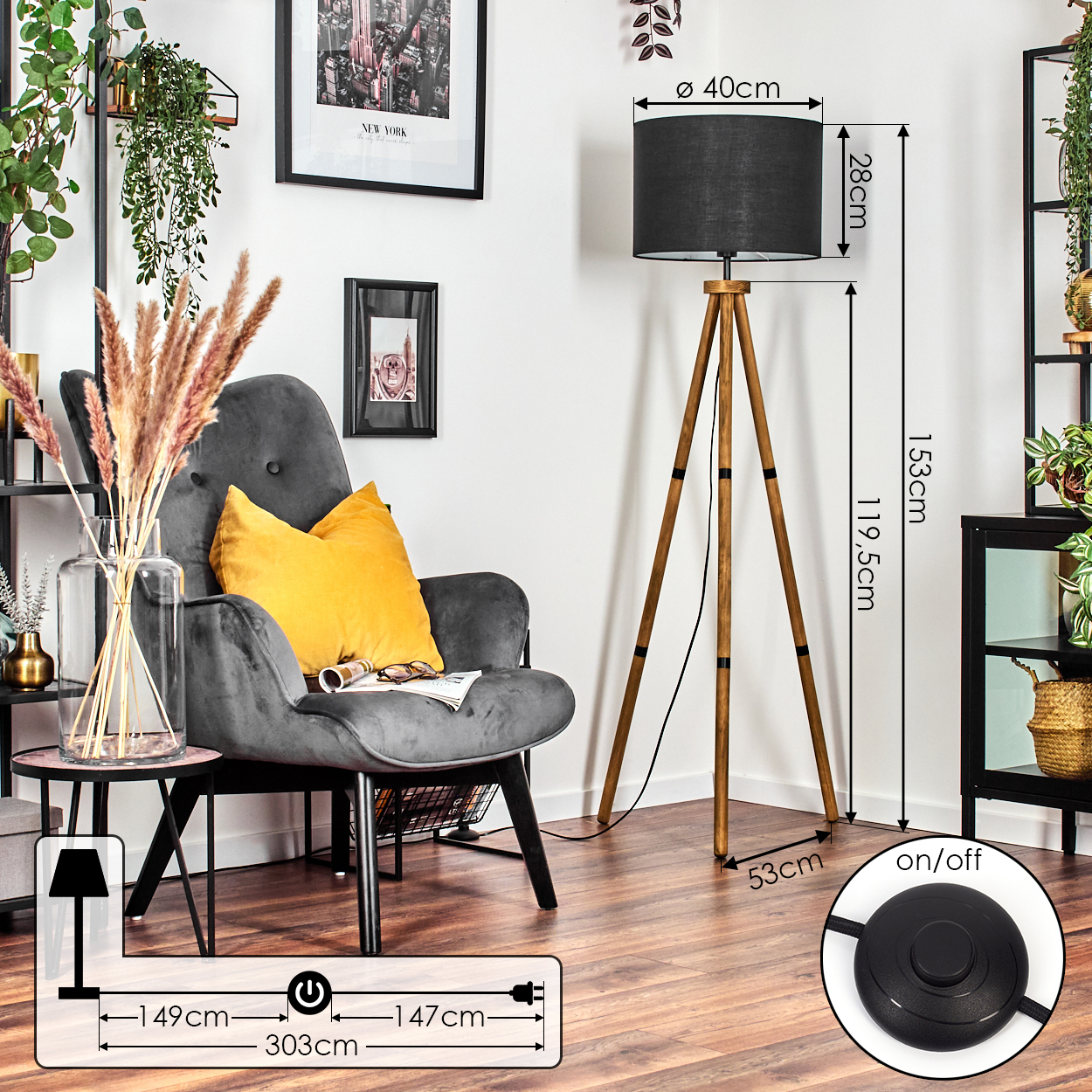 Ein Raum mit einem grauen Sessel, einer Stehlampe mit schwarzem Lampenschirm, einem Beistelltisch und einem gerahmten Bild an der Wand.