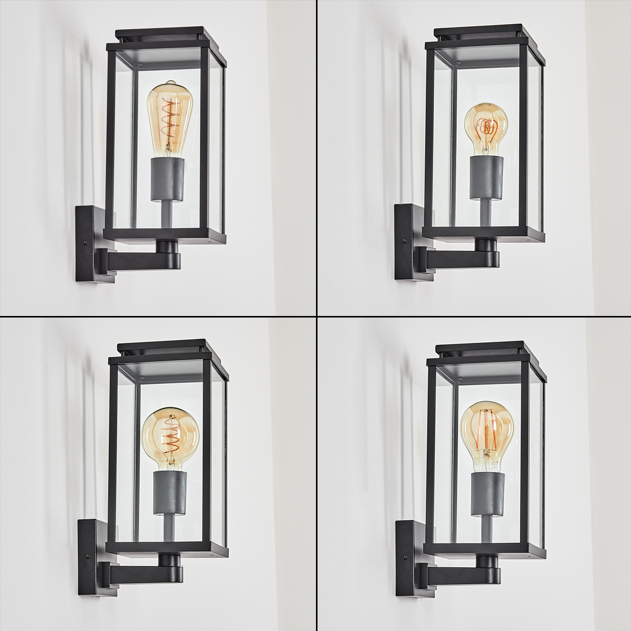 Vier schwarze Außenlampen mit klarer Glasumhüllung und einer Vintage-Edison-Glühbirne, an einer weißen Wand befestigt. Jede Lampe ist beleuchtet.