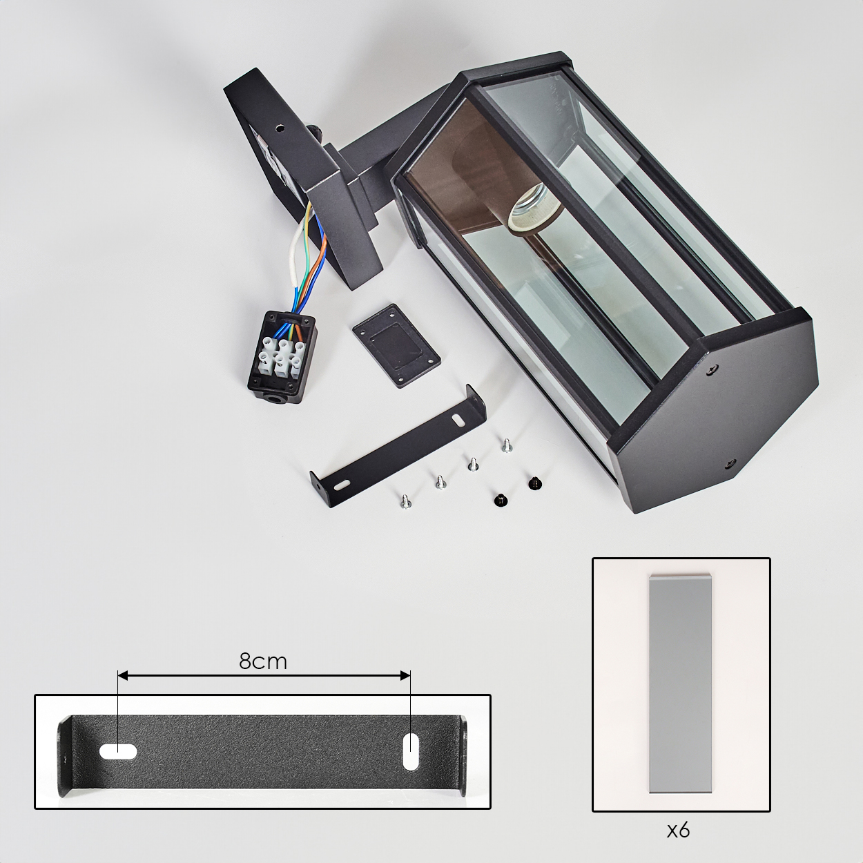 Schwarze Außenlampenteile auf Weiß verteilt. Enthält Lampe, Halterung, Schrauben und Elektrokasten, mit 8cm Halterung.