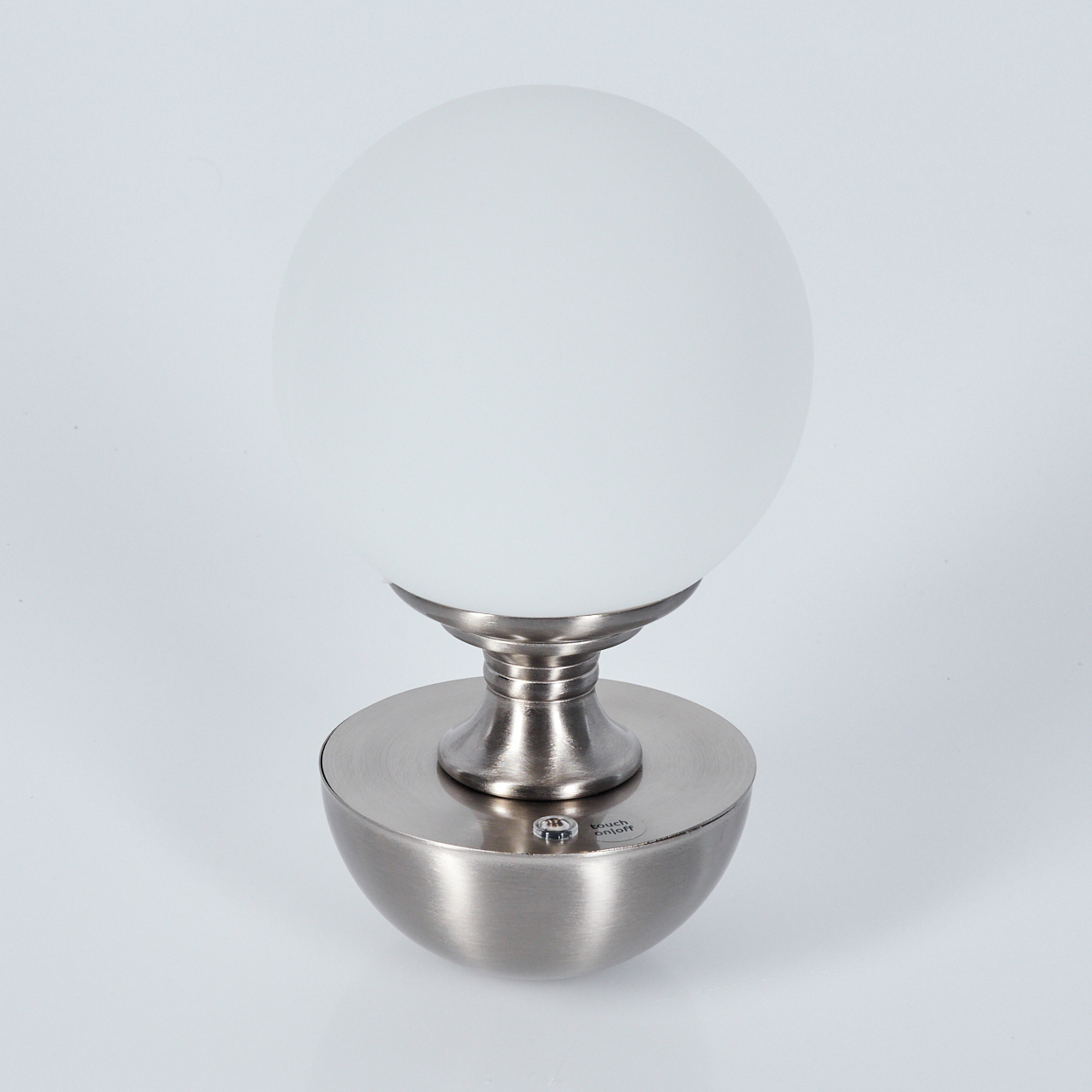 Eine moderne Lampe mit weißem Kugelschirm und Metallfuß. Die Lampe steht auf einer weißen Oberfläche, mit dem Wort 'touch on/off'.
