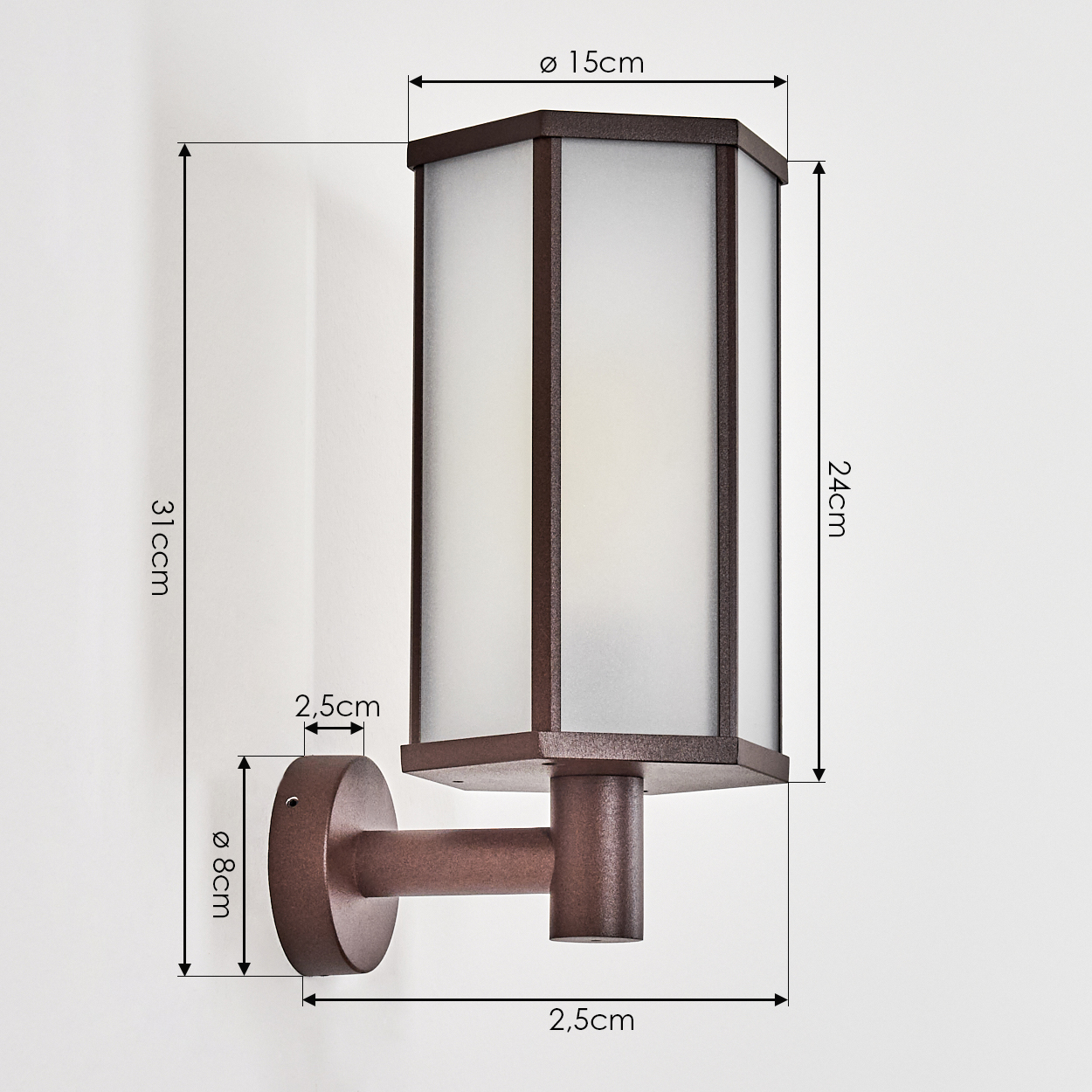 Eine bronzefarbene Außenwandleuchte mit Abmessungen. Die Lampe hat einen rechteckigen, mattierten Glasschirm in einem Metallrahmen, an einer weißen Wand montiert.