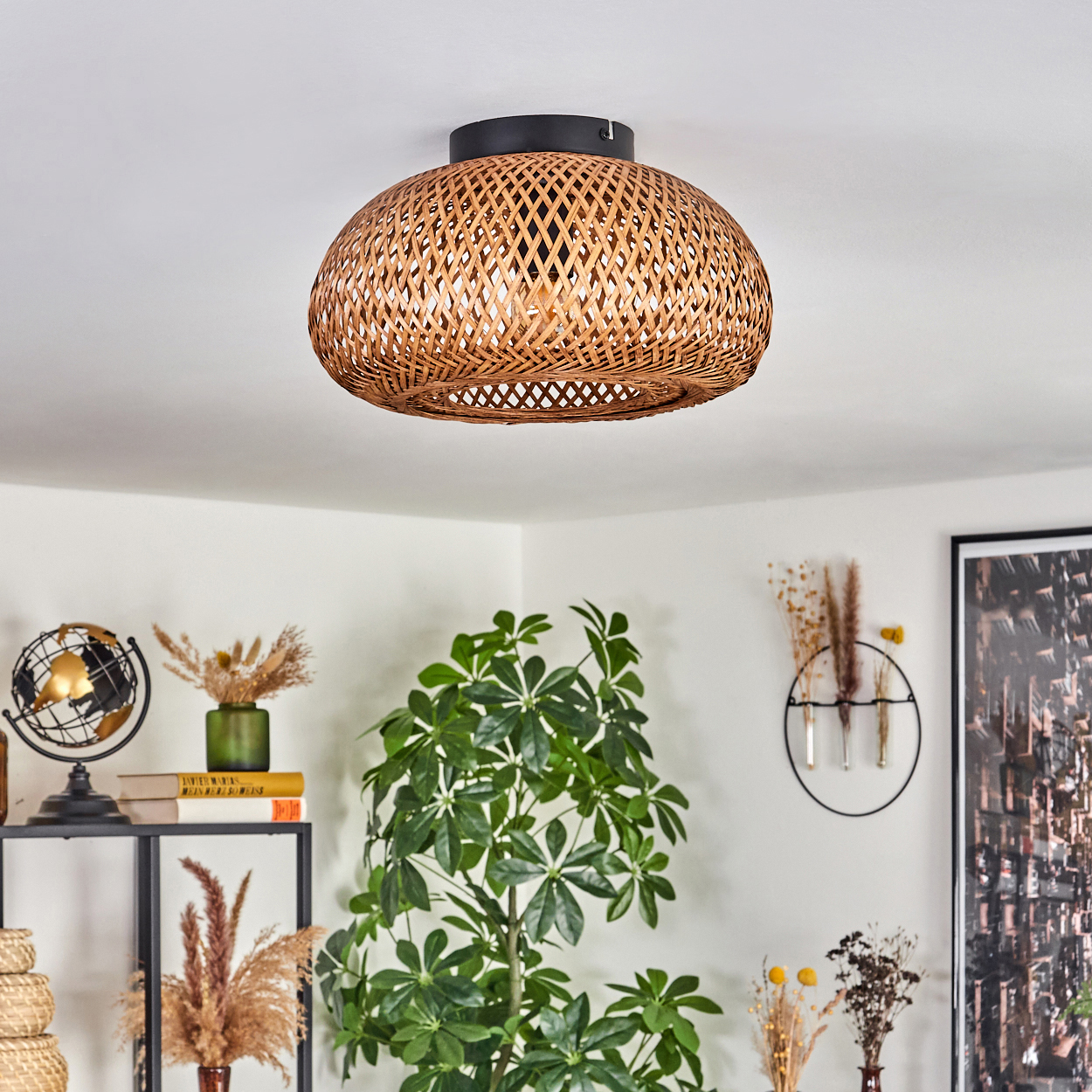 Ein gewebter Lampenschirm aus Rattan hängt an der Decke. Darunter befinden sich Pflanzen, ein Globus und Dekoration.