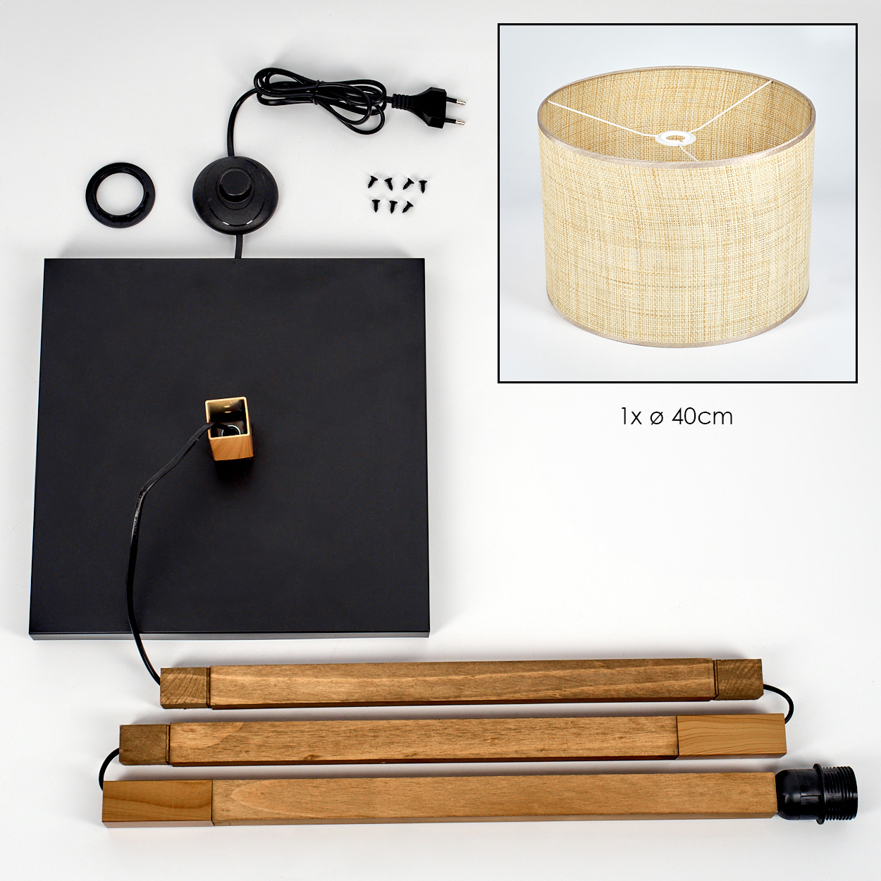 Lampenteile: schwarze Basis, Holzstäbe, Lampenschirm, Schrauben, Netzkabel und Schalter sowie Fassung. Teile auf weißer Oberfläche angeordnet.