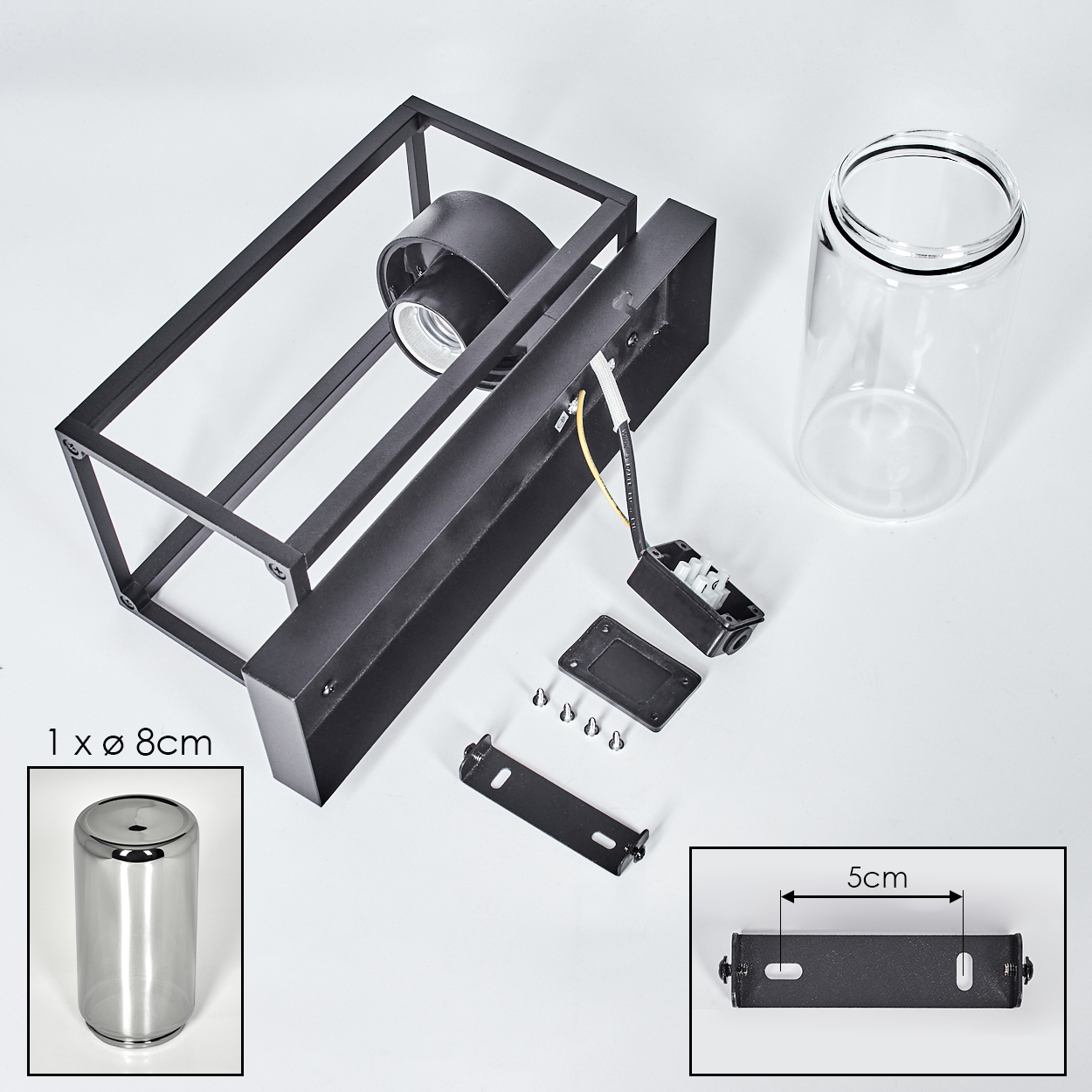 Schwarze Metallleuchtenkomponenten, Glaszylinderschirm und Montagematerial sind auf einer weißen Oberfläche angeordnet.
