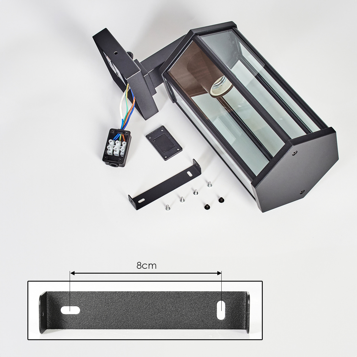 Schwarze Außenlampenteile auf weißer Oberfläche angeordnet. Enthält Lampe, Halterung, Schrauben und elektrische Komponenten. Eine Halterung misst 8 cm.