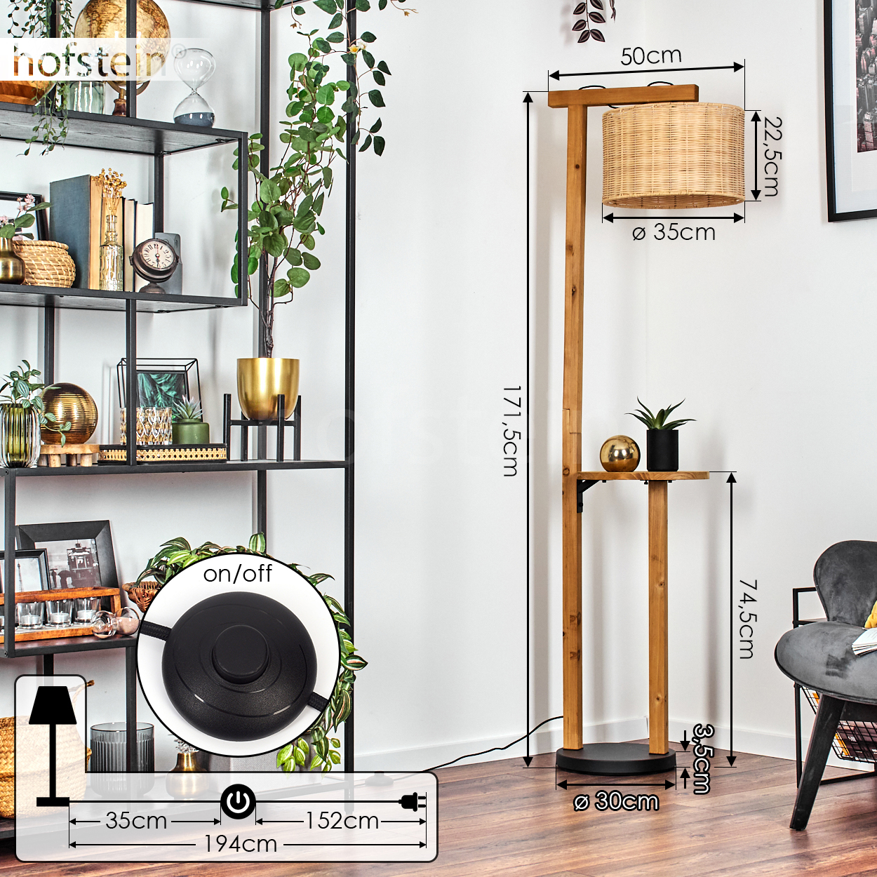 Eine hölzerne Stehlampe mit gewebtem Lampenschirm. Sie hat ein kleines Regal. Links ein schwarzes Metallregal mit Dekorationsartikeln.