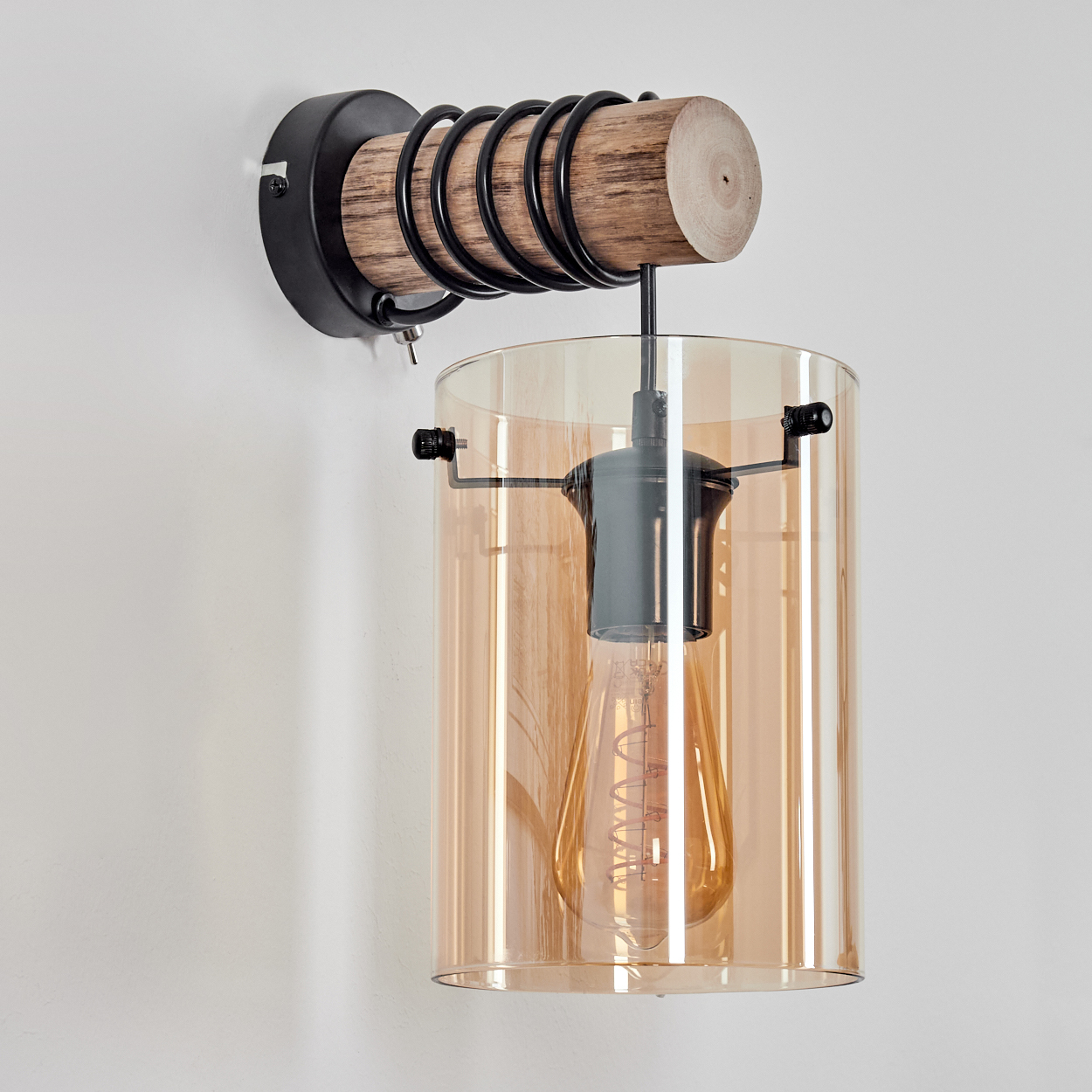 Eine Wandleuchte. Sie hat einen Holzsockel, schwarze Metallakzente und einen bernsteinfarbenen Glasschirm. Im Inneren befindet sich eine Edison-Glühbirne.