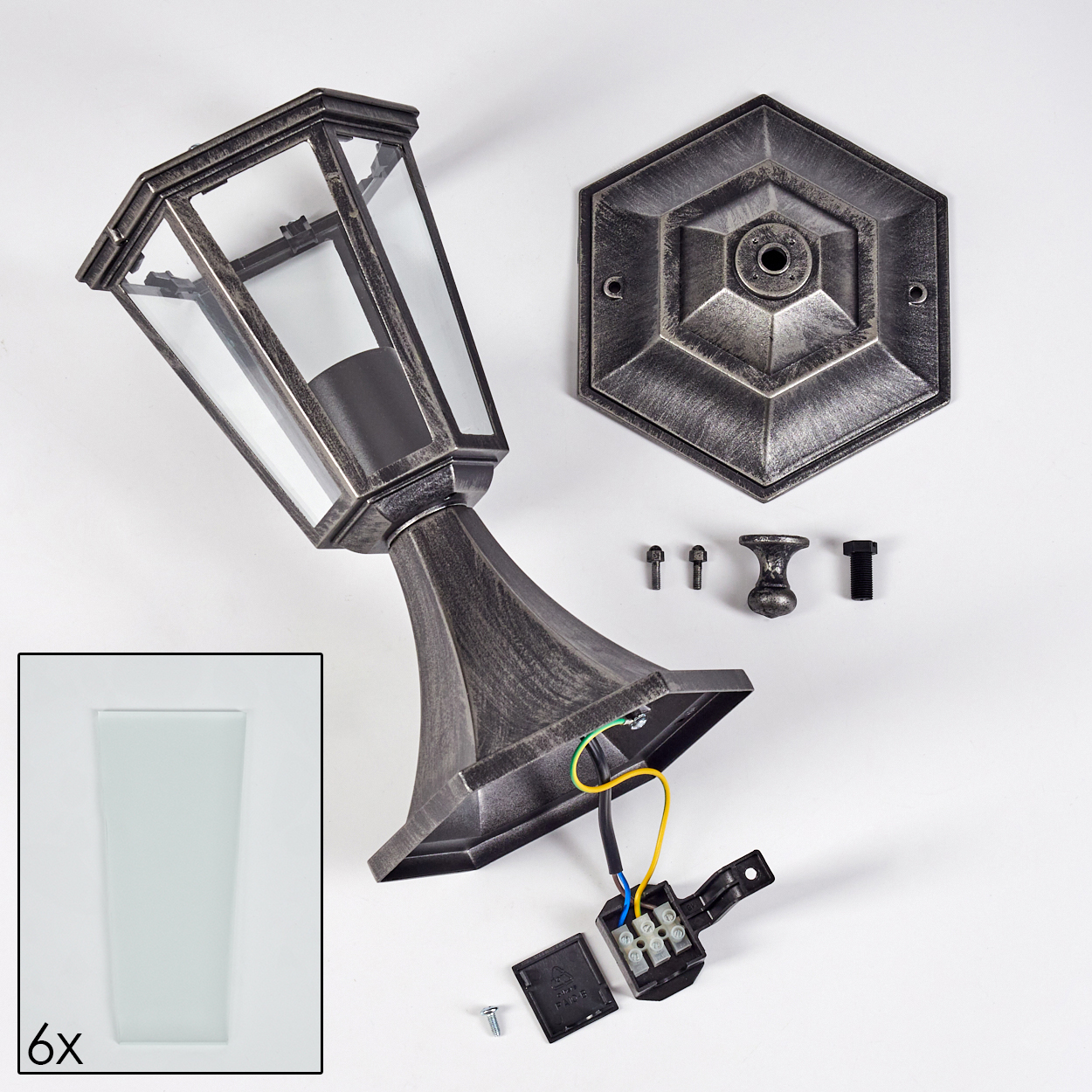 Zerlegte Lampenkomponenten auf weißer Oberfläche. Enthält Lampe, Sockel, Sechseckplatte, Schrauben und Glasscheiben (6x).
