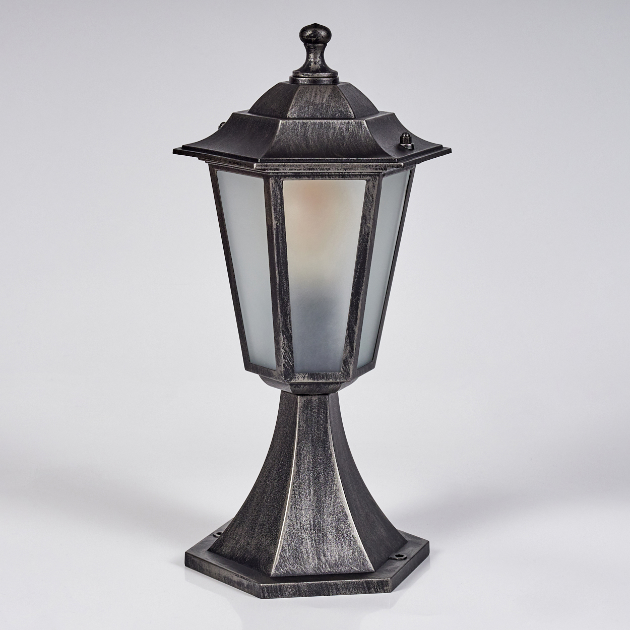 Eine dekorative Außenlampe mit metallischem Finish. Sie hat einen Schirm aus Milchglas und befindet sich vor einem weißen Hintergrund.