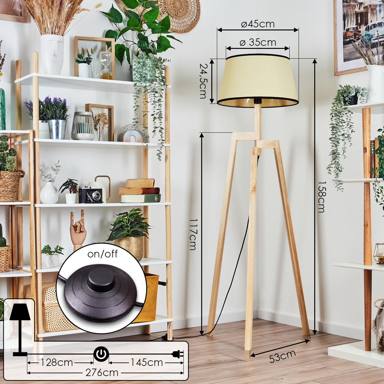 Eine Holz-Stativ-Stehlampe mit beigem Lampenschirm steht neben einem weißen Regal mit Pflanzen und Dekoration.