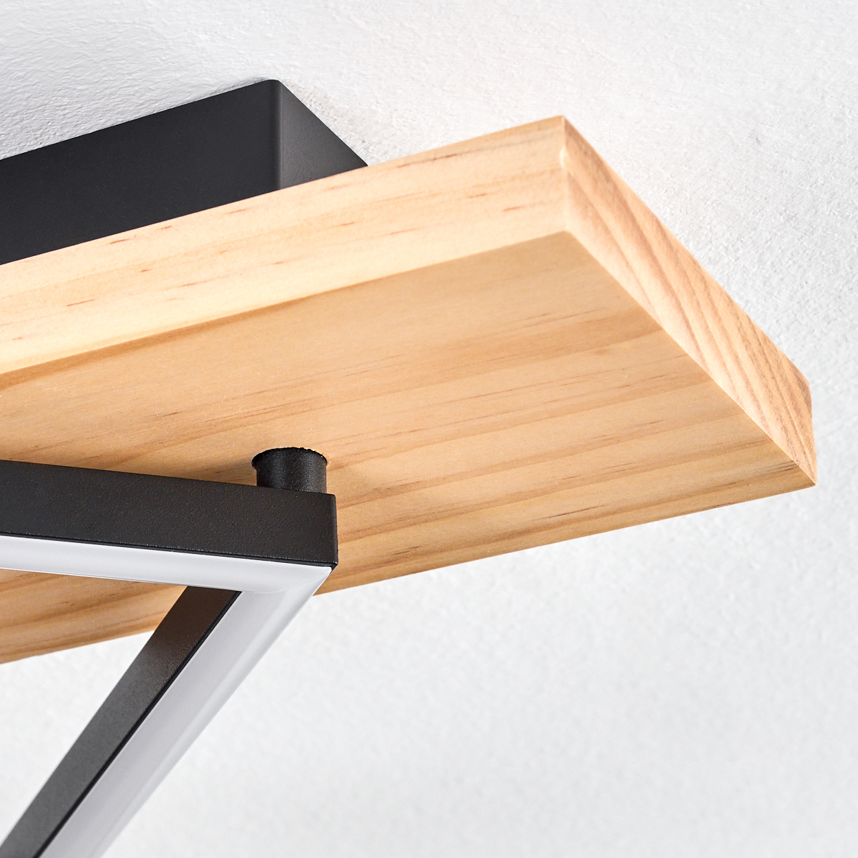Nahaufnahme eines Holzregals, das von einem schwarzen Metallrahmen getragen wird. Das Regal hat eine natürliche Holzmaserung. Der Hintergrund ist weiß.
