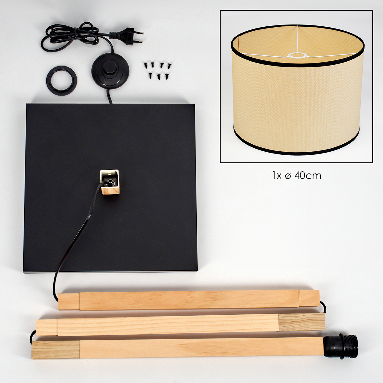 Komponenten einer Lampe: ein schwarzer Sockel, Schirm, Holzstützen, Schrauben, ein Netzkabel und ein Fußschalter, alles auf weißem Grund.