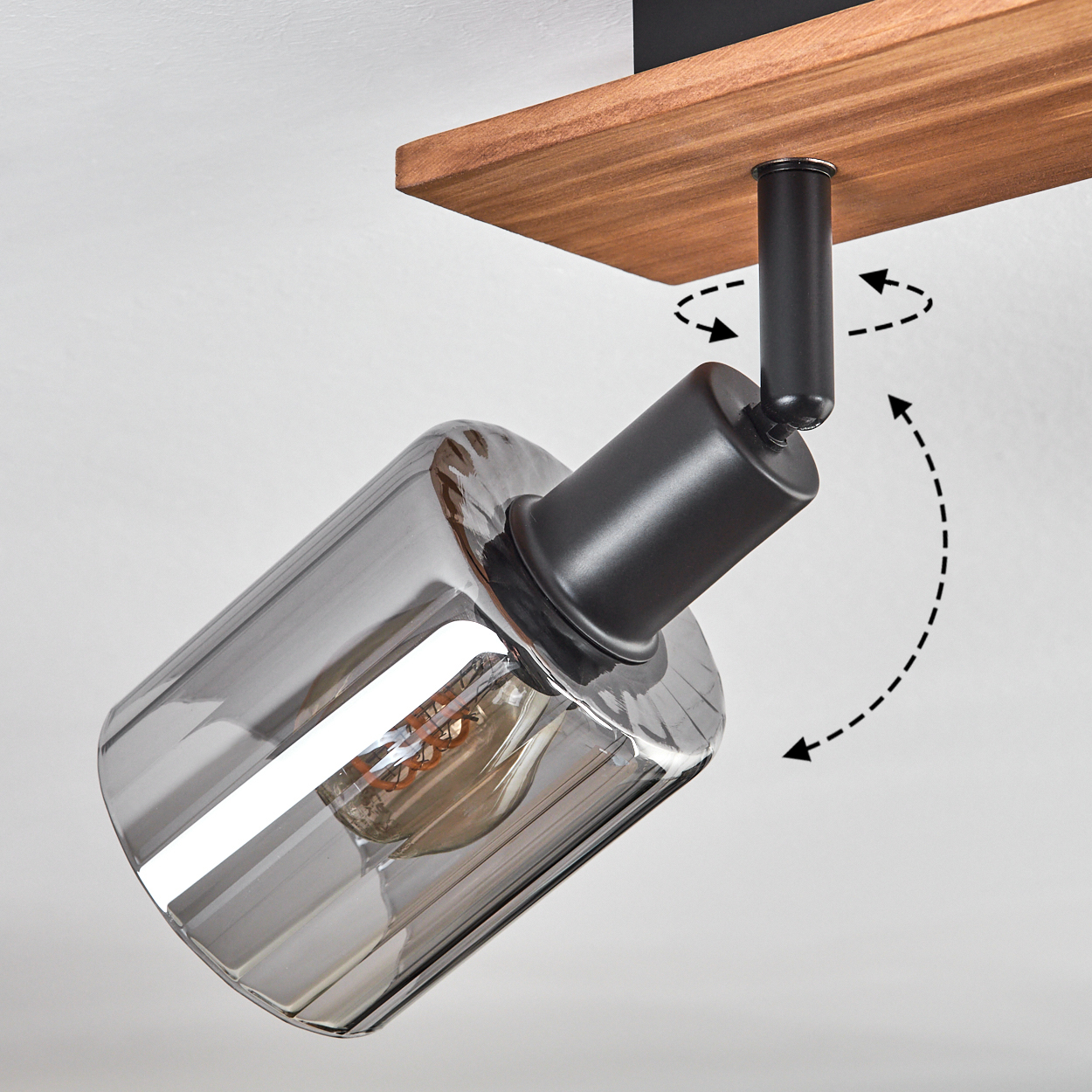 Eine moderne Deckenleuchte mit Holzpaneel. Die Leuchte hat einen Glasschirm und kann mit schwarzen Pfeilen verstellt werden.