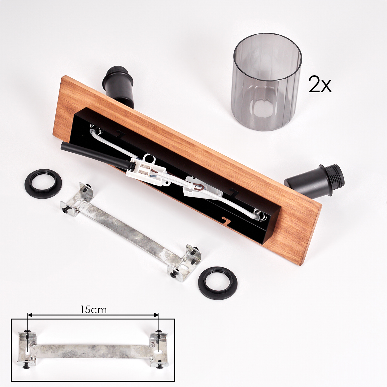 Zerlegte Lampenkomponenten. Holzsockel, schwarze Armaturen, Metallhalterung, zwei Lampenfassungen, zwei Glasschirme und zwei schwarze Ringe.