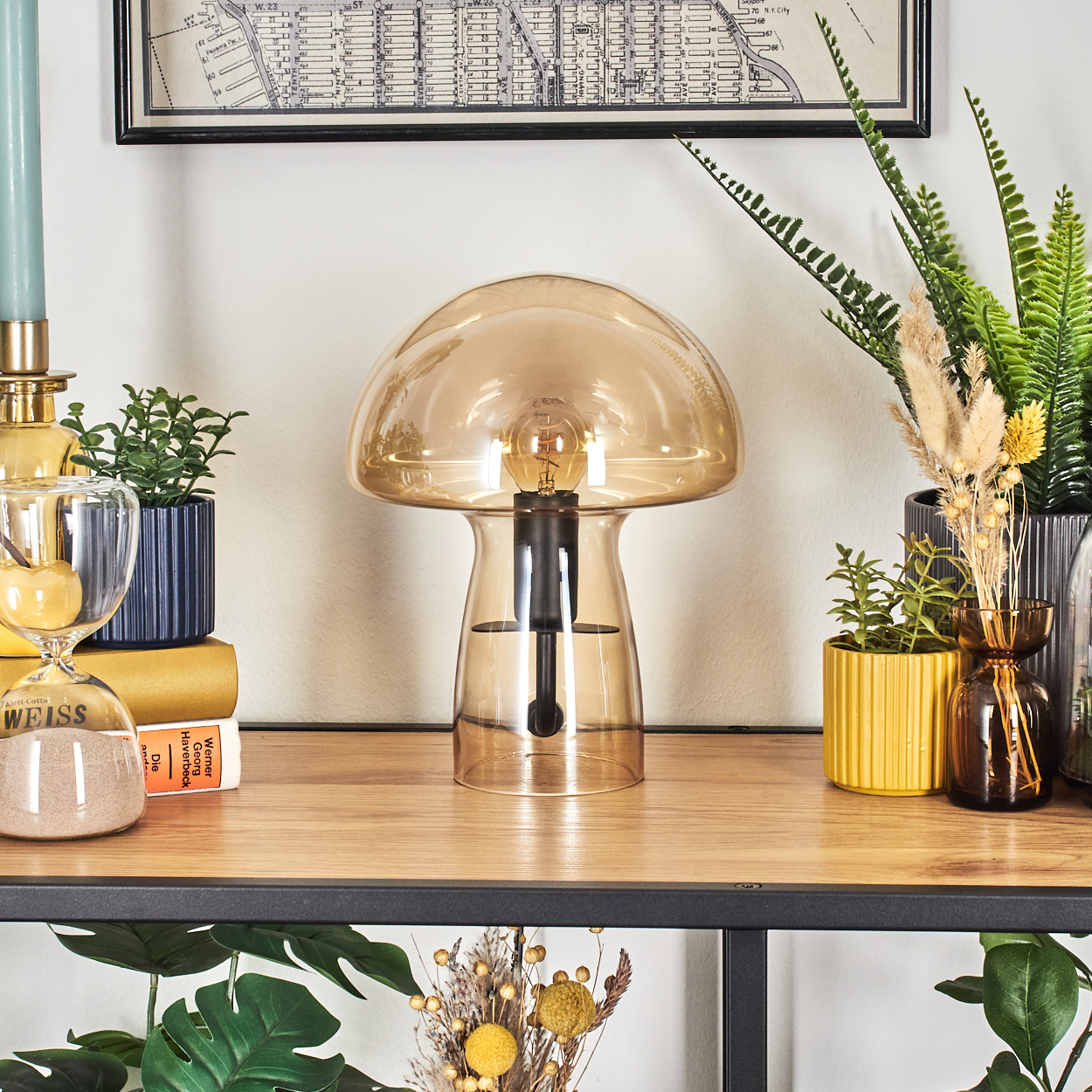 Eine pilzförmige Lampe steht auf einem Holzregal mit Pflanzen, einer Karte und einer Sanduhr. Verschiedene Farben sind sichtbar.
