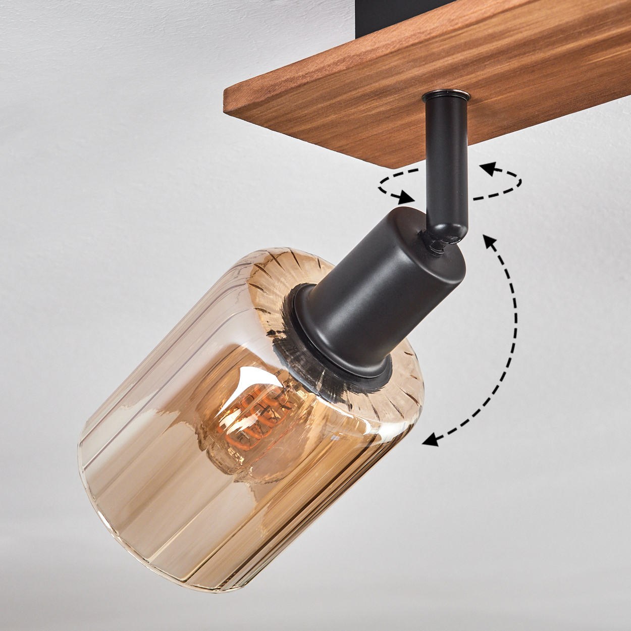Ein Deckenstrahler mit braunem Holzsockel. Das Licht ist bernsteinfarben und hat einen gerippten Glasschirm mit schwarzem Metallsockel.