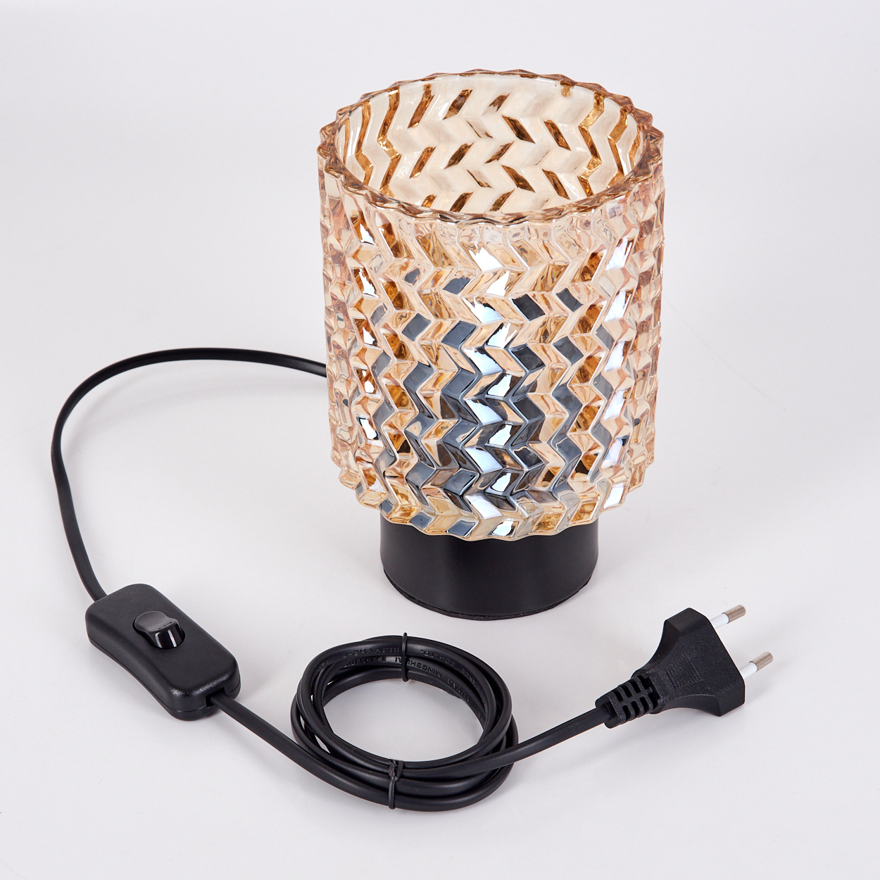 Eine dekorative Lampe mit gemustertem Glasschirm, schwarzem Sockel und Netzkabel mit Schalter und Stecker, vor weißem Hintergrund.