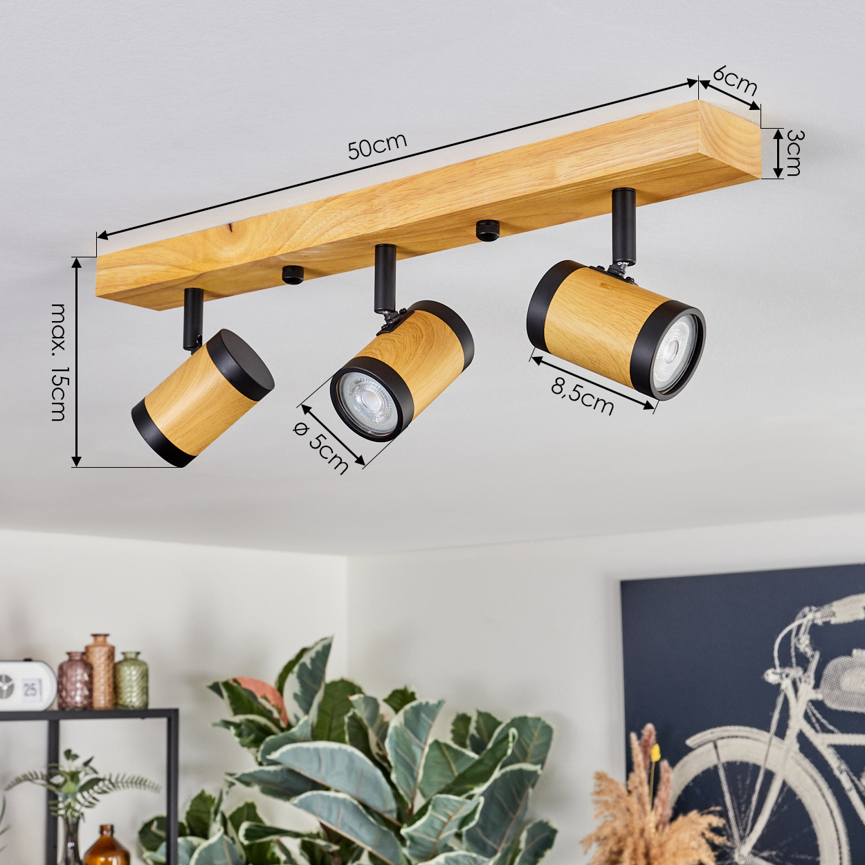 Holz-Deckenleuchte mit drei Strahlern. Abmessungen: 50 cm lang, max. 15 cm hoch. Die Strahler haben eine Holzoberfläche.