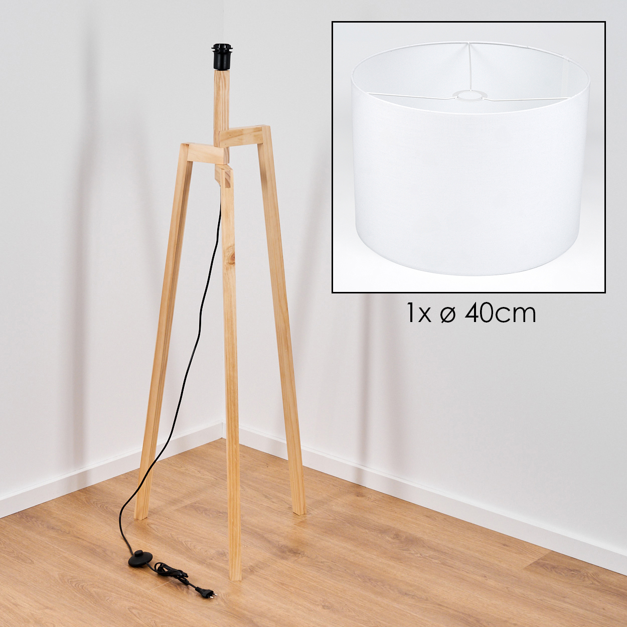 Holz-Stativ-Stehlampe mit Lampenschirm in einer Ecke. Der Lampenschirm ist weiß, die Beine sind helles Holz und das Kabel ist schwarz.