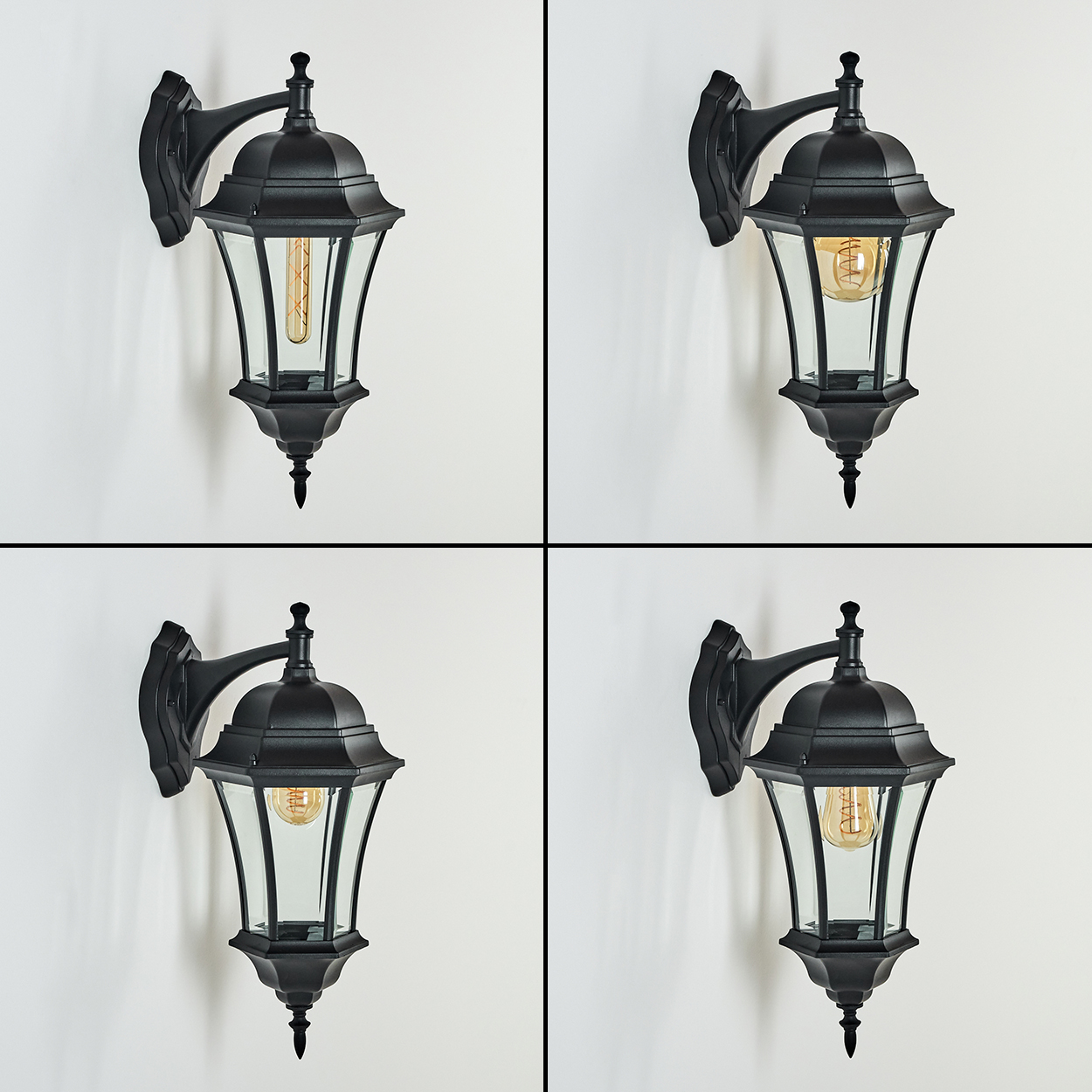 Vier schwarze Wandlampen mit klaren Glasscheiben und leuchtenden Glühbirnen, an einer weißen Wand befestigt. Jede Lampe hat ein dekoratives Oberteil.