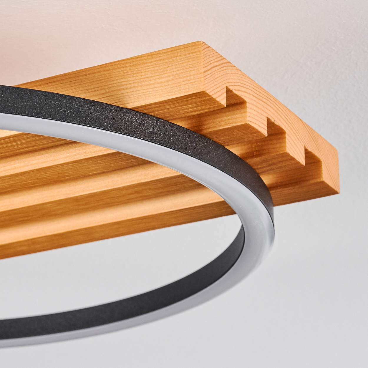 Moderne Deckenleuchte. Sie verfügt über einen Holzbalken und einen kreisförmigen schwarzen Rahmen mit weißem LED-Licht.