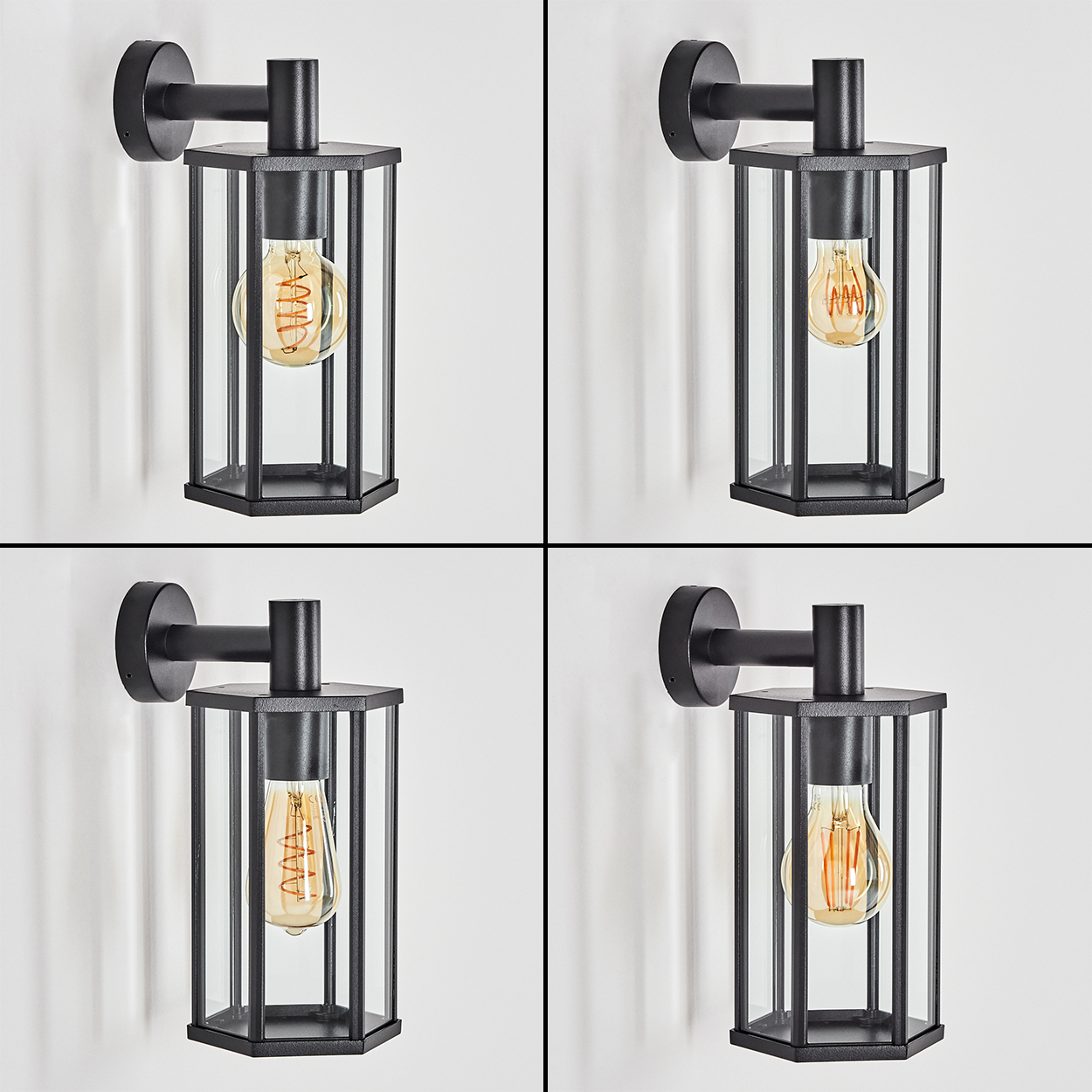 Vier schwarze Wandlampen. Jede hat einen sechseckigen Glasschirm mit einer Glühbirne im Inneren, montiert an einer weißen Wand.