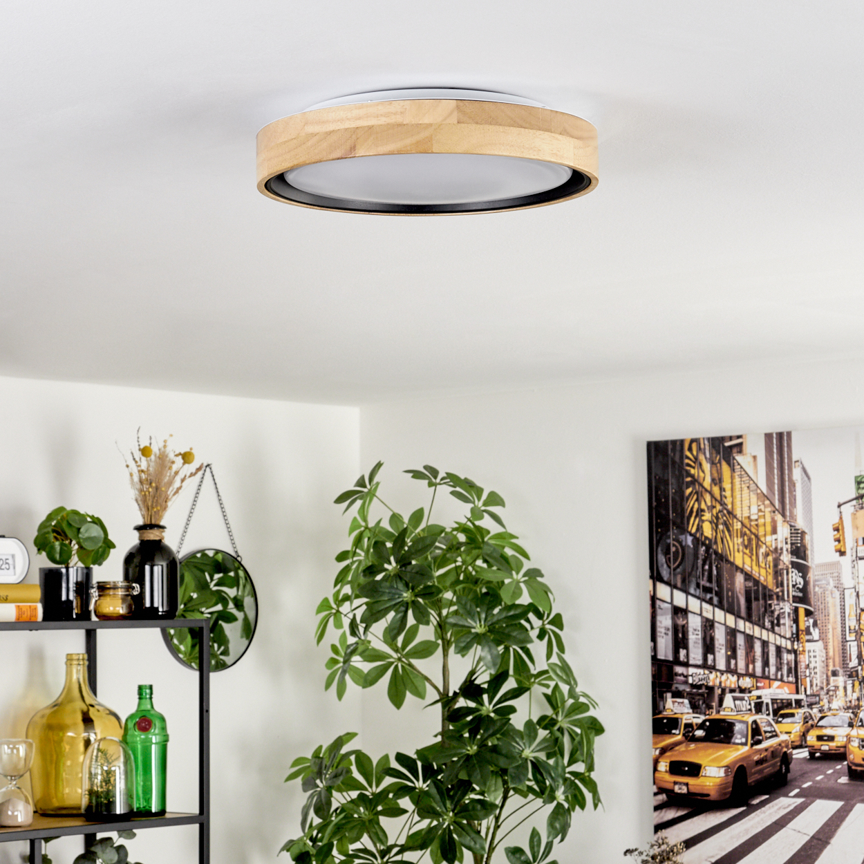 Deckenleuchte mit Holzverkleidung, Pflanzen, Regal mit Dekor und eine New Yorker Szene an der Wand. Weiße Wände und Decke.