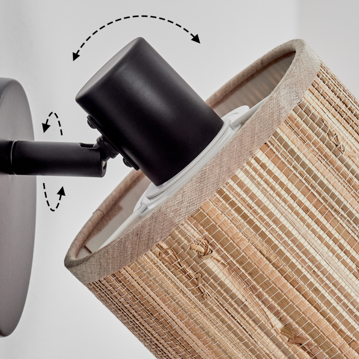 Eine Wandlampe mit gewebtem Lampenschirm. Der schwarze Lampenarm ist verstellbar. Pfeile zeigen die Bewegung an. Der Hintergrund ist weiß.