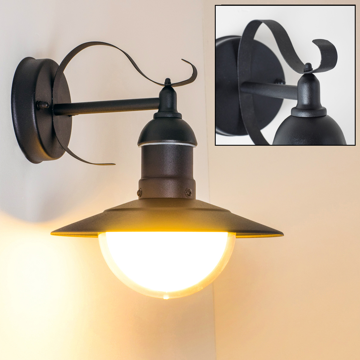 Schwarze Wandleuchte mit gebogenem Arm und nach unten gerichtetem Lampenschirm. Die Lampe befindet sich an einer weißen Wand. Die Lampe leuchtet.