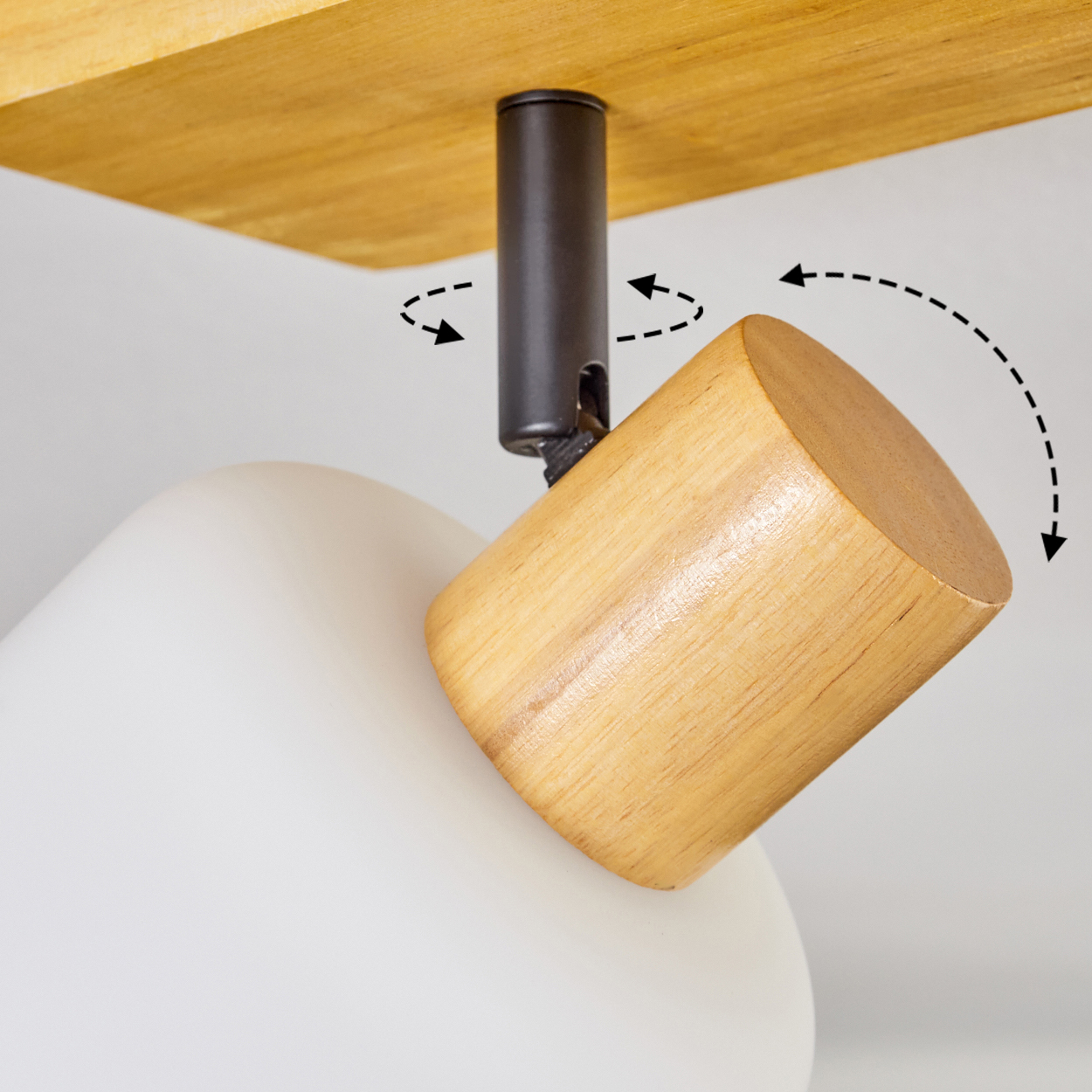 Eine Holz- und weiße Lampe ist zu sehen. Ein Holzzylinder ist an einer dunklen Metallstütze befestigt, die mit einer Holzdecke verbunden ist.