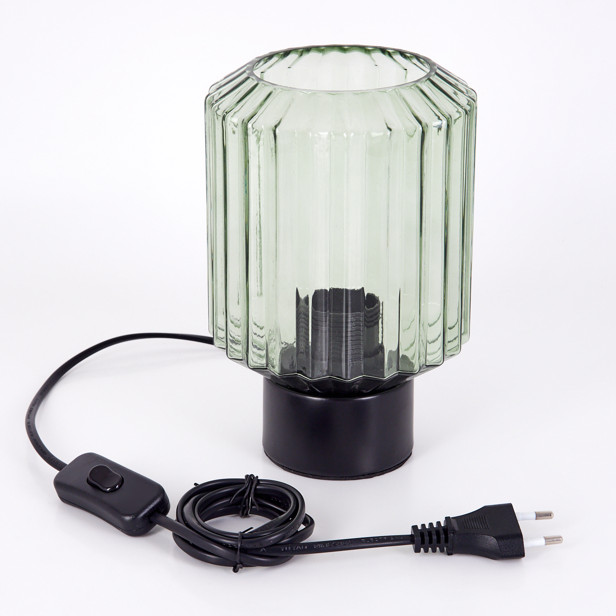 Eine grüne Glaslampe mit schwarzem Sockel und Kabel, Schalter und Stecker auf weißem Untergrund.