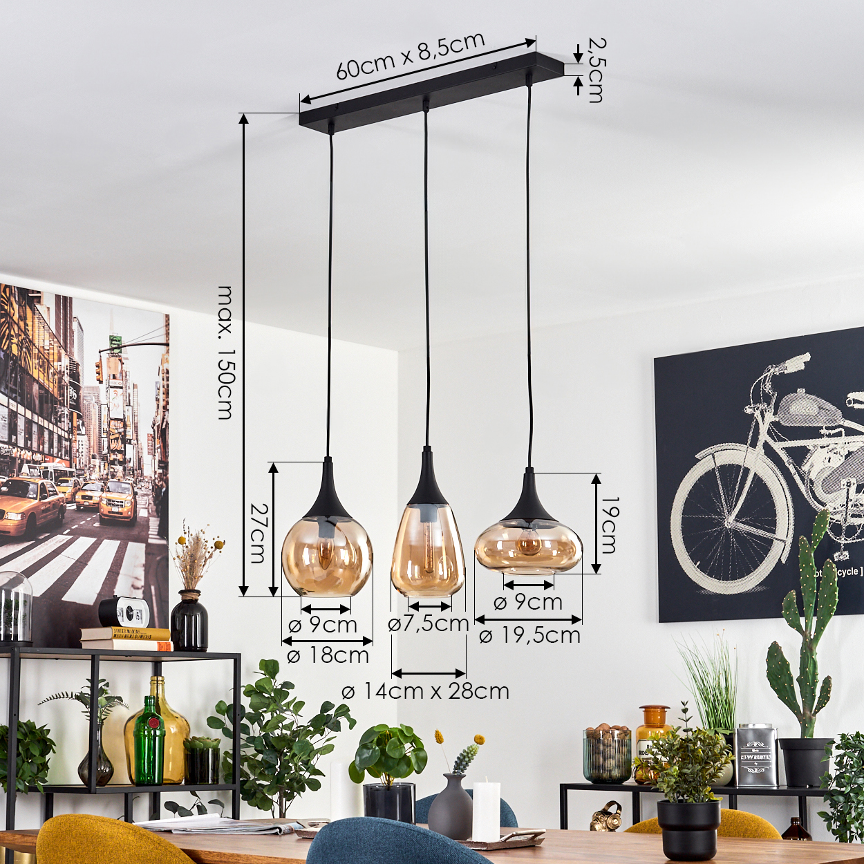 Drei Pendelleuchten mit bernsteinfarbenen Glasschirmen hängen von einer schwarzen rechteckigen Halterung. Maße sind beschriftet. Kunst und Pflanzen im Hintergrund.