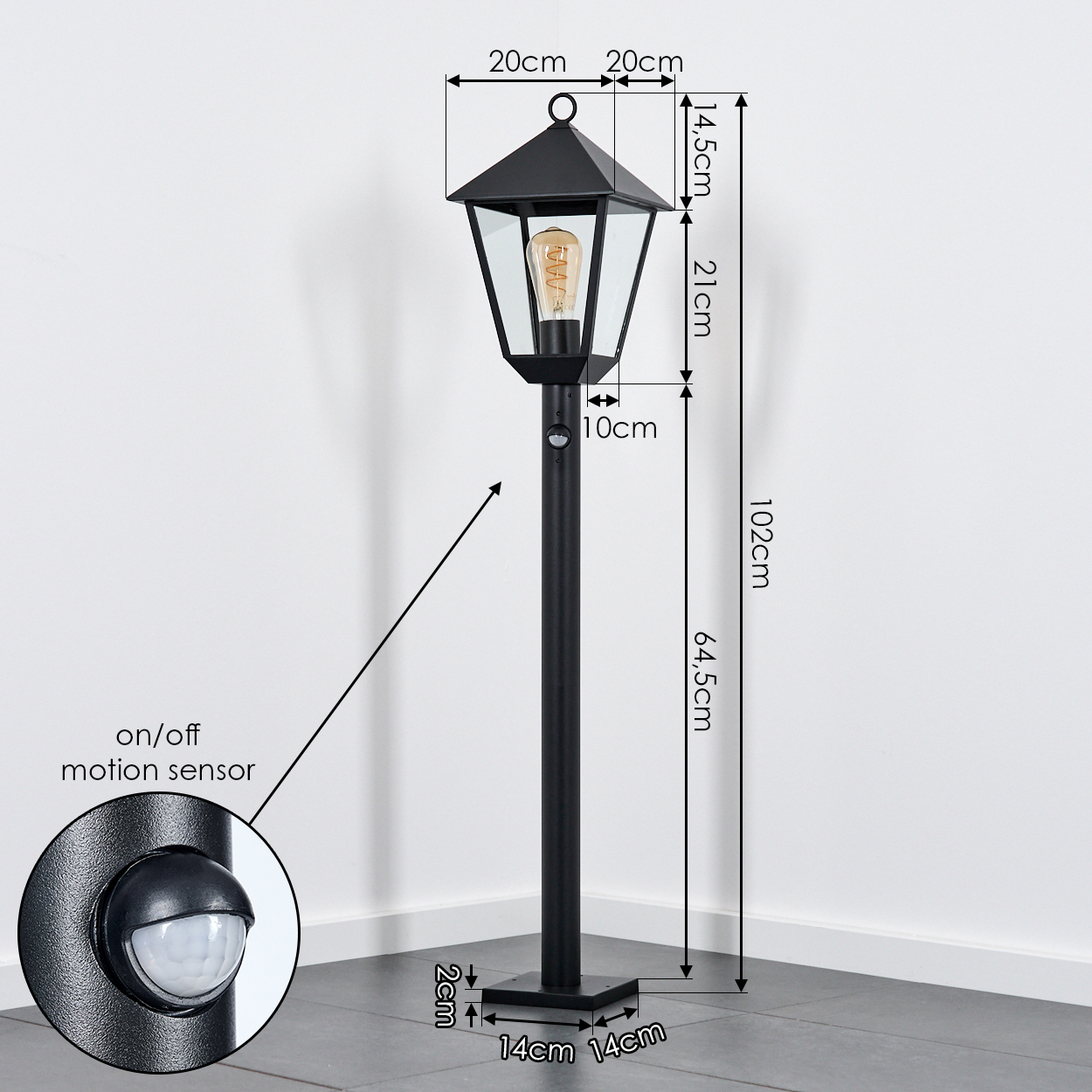 Schwarze Außenlampe mit Maßangaben. Enthält einen Ein/Aus-Bewegungssensor. Die Lampe steht auf einem grauen Fliesenboden.